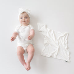 Baby wearing Bow Headband in Cloud  next to Cloud Kite Lovey