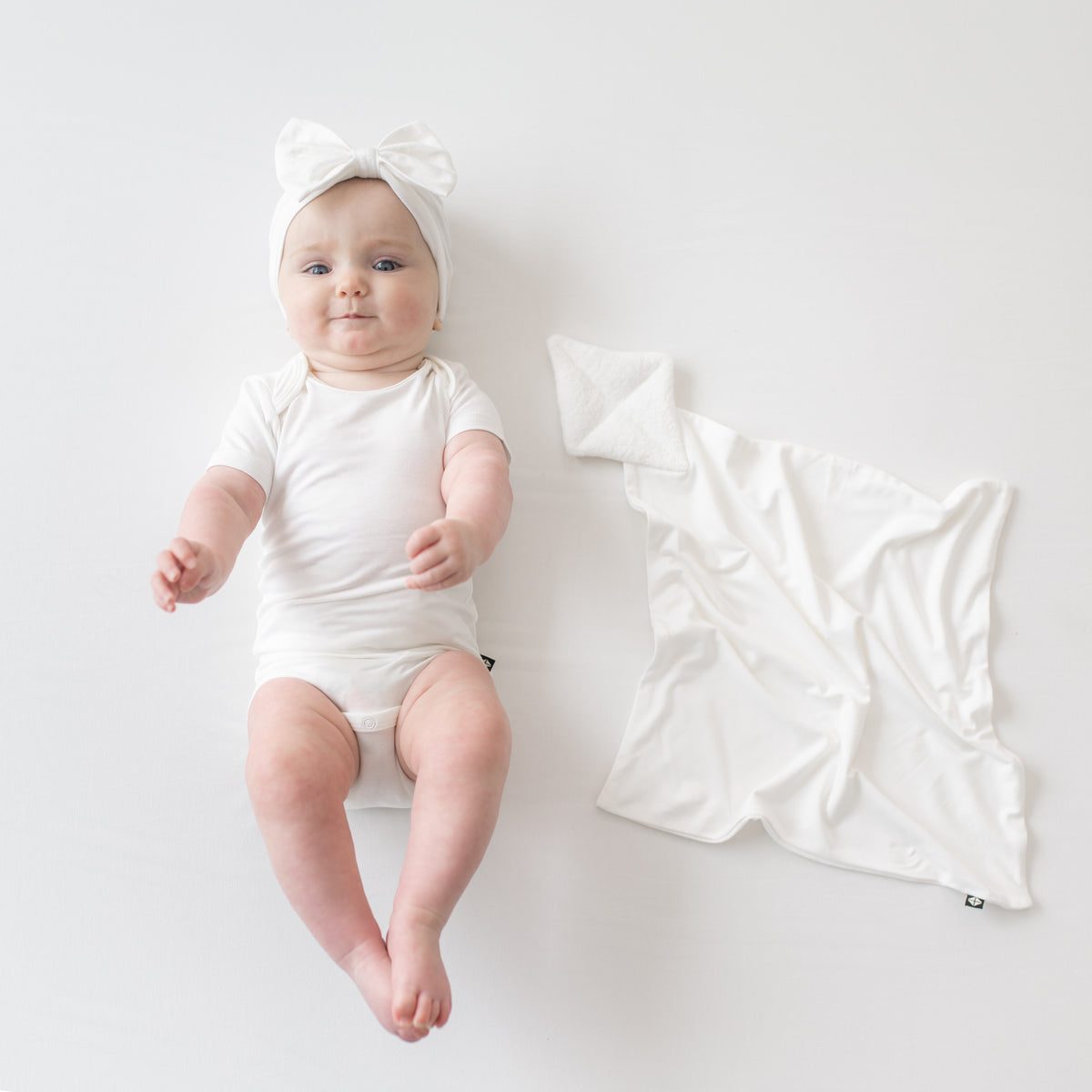 Baby wearing Bow Headband in Cloud  next to Cloud Kite Lovey