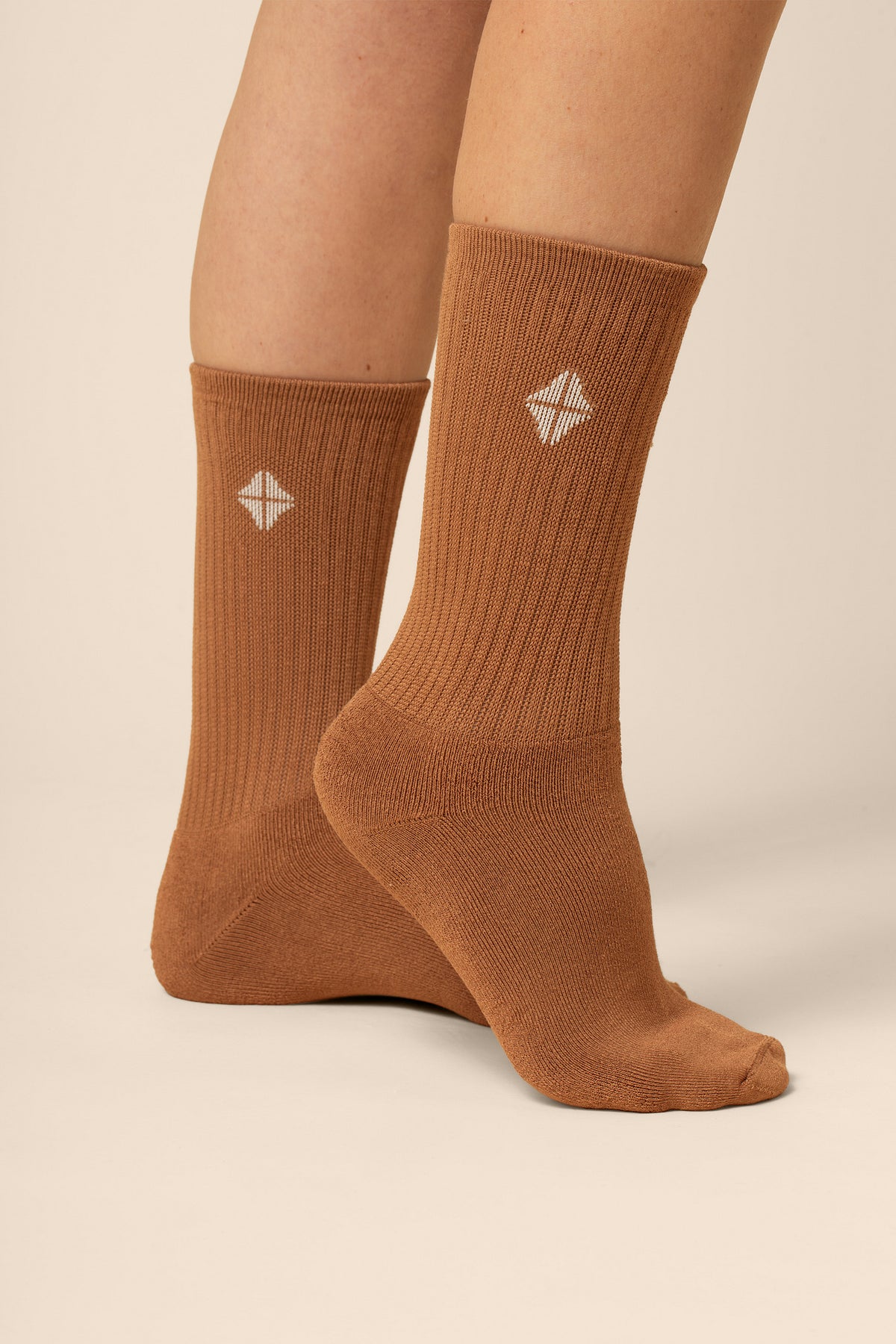 Brown socks with a white geometric design on a beige background