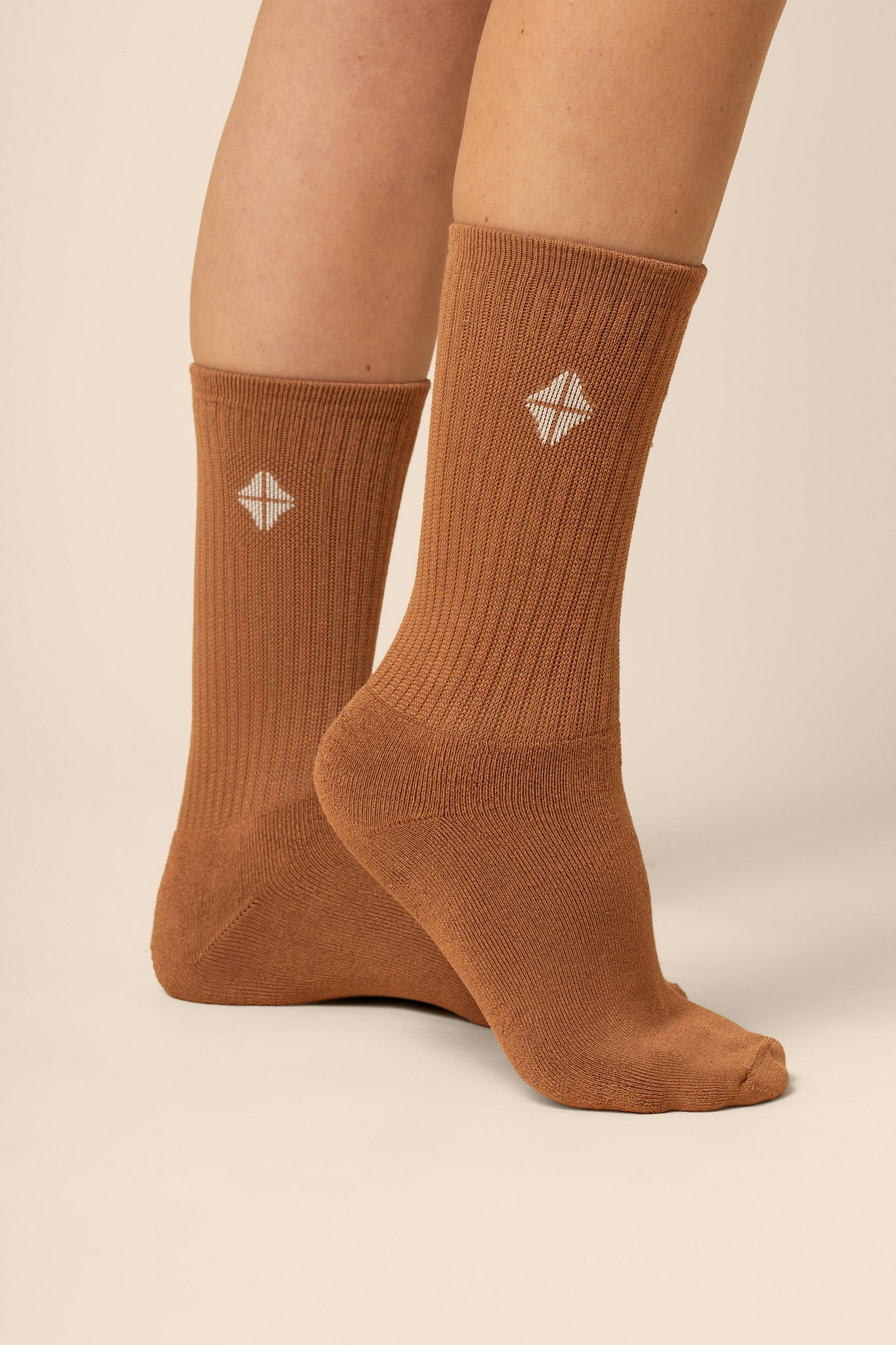 Brown socks with a white geometric design on a beige background