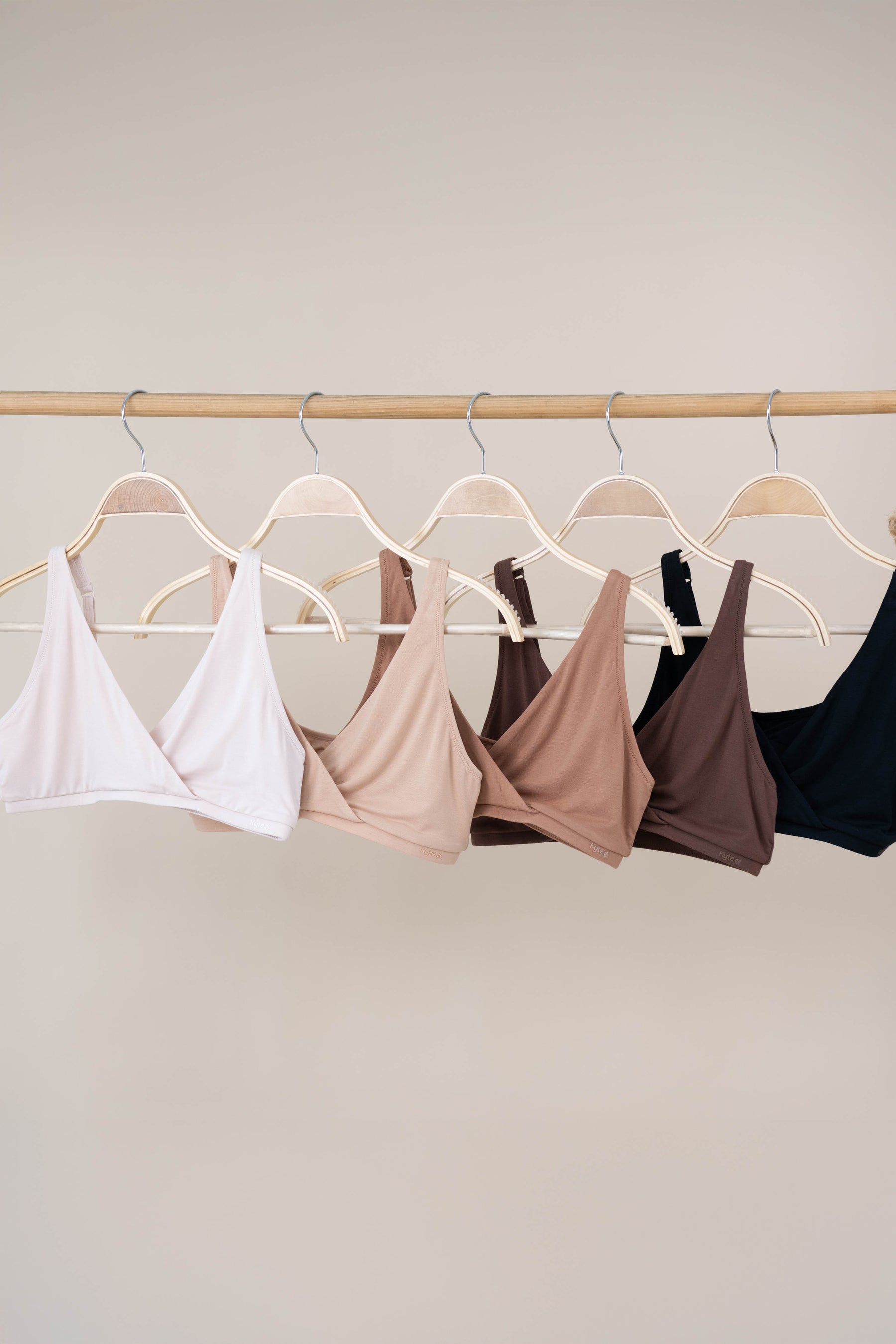 Women's Cross Front Bralette in Neutral colors hanging on hangers