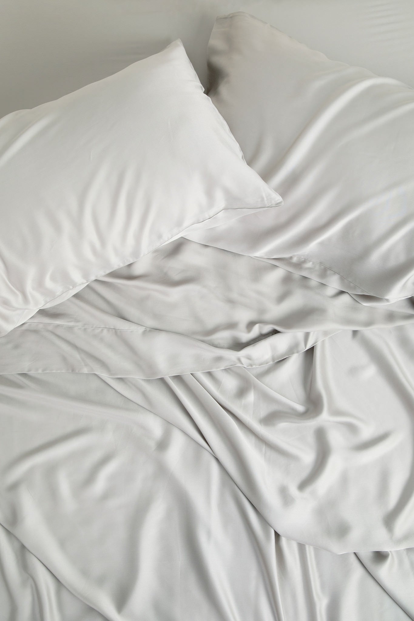 Bamboo Sateen Pillowcase Set in Dove Gray and matching bed sheets shown on a bed