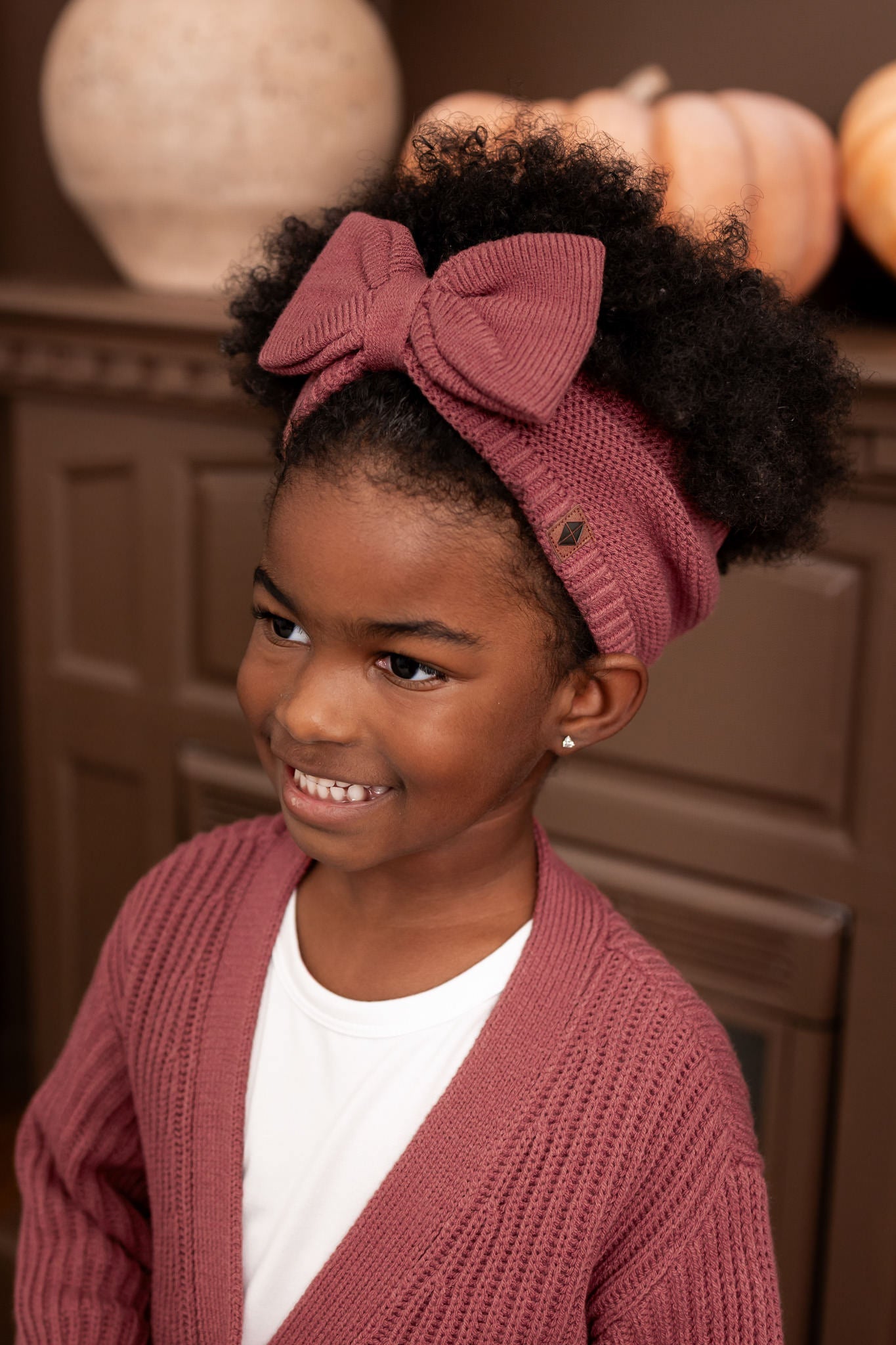 Child wearing Chunky Knit Bow Headband in Ember over White T-shirt and chunky knit oversized cardigan in ember