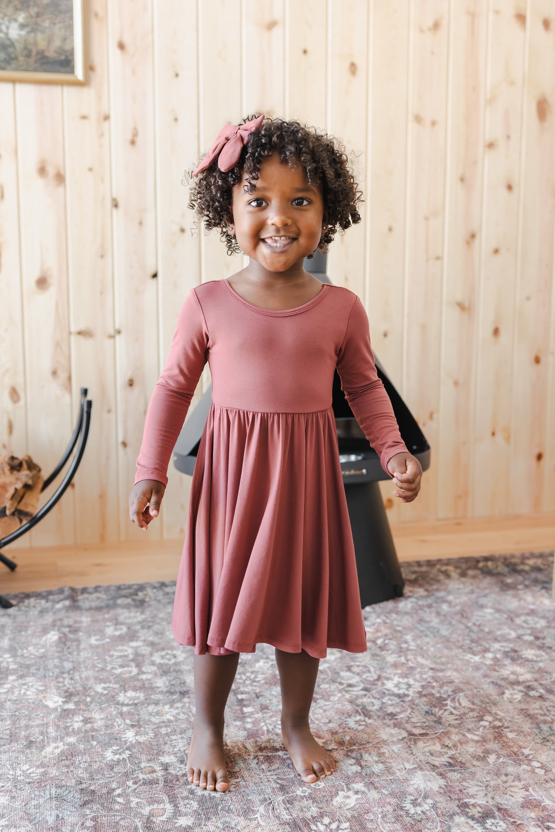 Girl wearing Long Sleeve Twirl Dress in Ember with Medium Alligator Clip Bow in Ember
