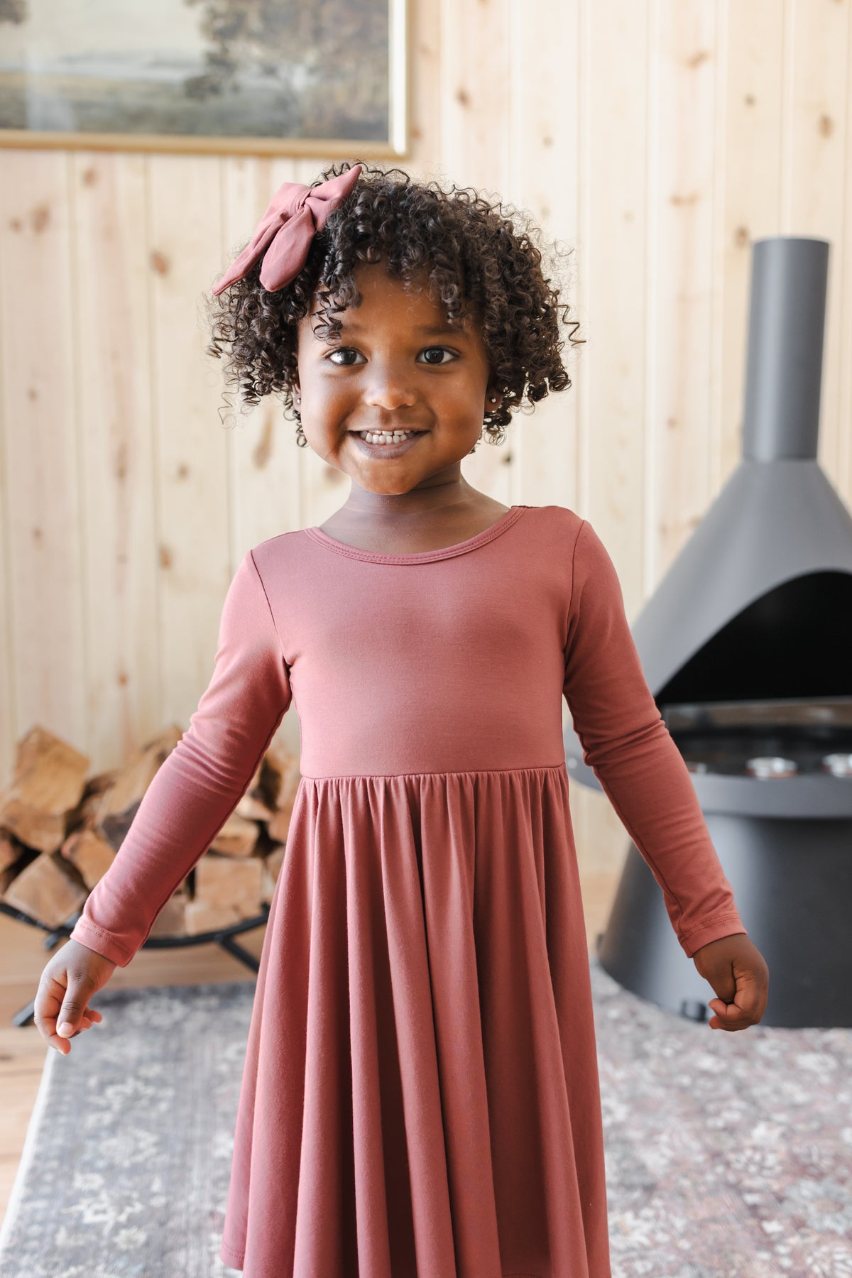 Girl wearing Long Sleeve Twirl Dress in Ember with Medium Alligator Clip Bow in Ember
