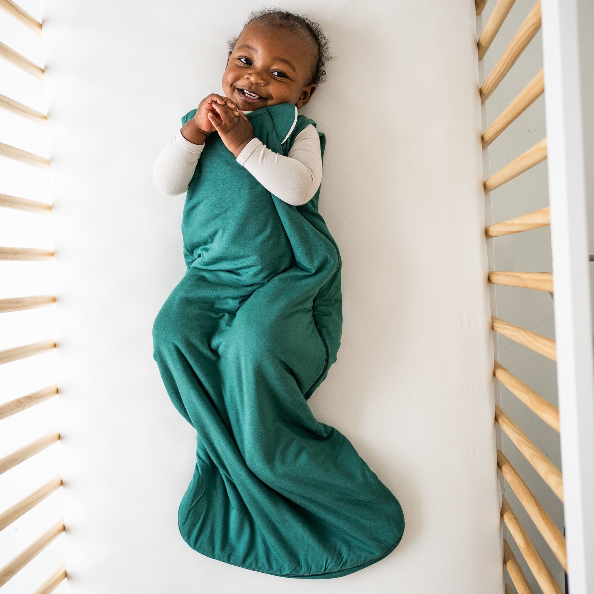 baby in crib wearing emerald sleep bag