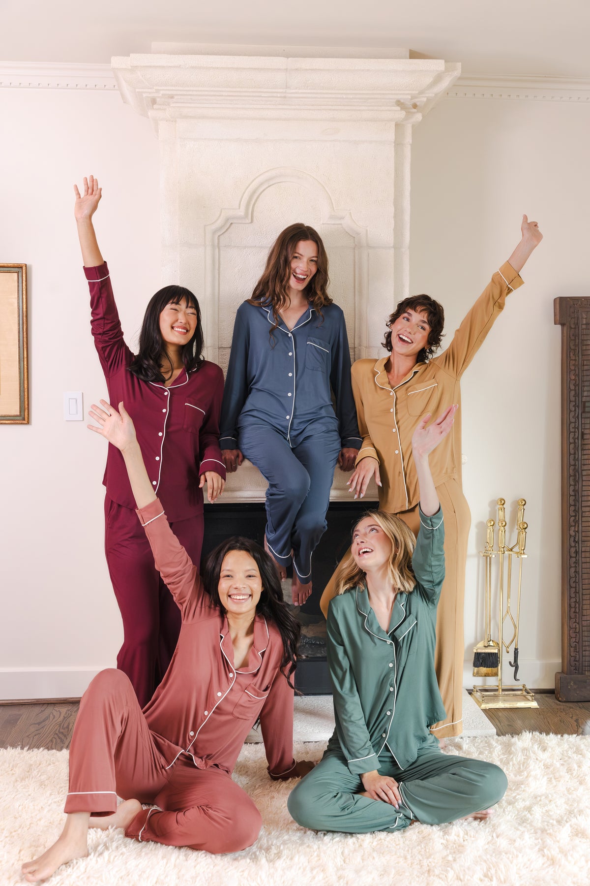 5 modals wearing Long-Sleeved Women's Pajama Set in Burgundy, pine, oxford, ochre and ember posing in a living room