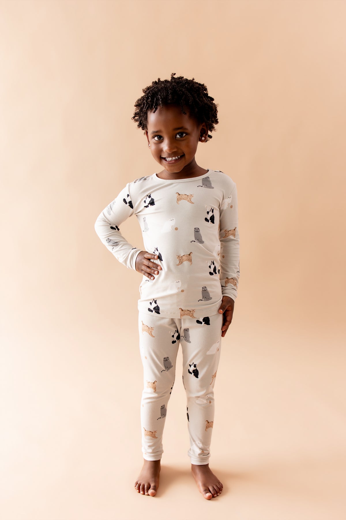 Smiling child posing wearing the Long Sleeve Pajamas in Fluffy Cat
