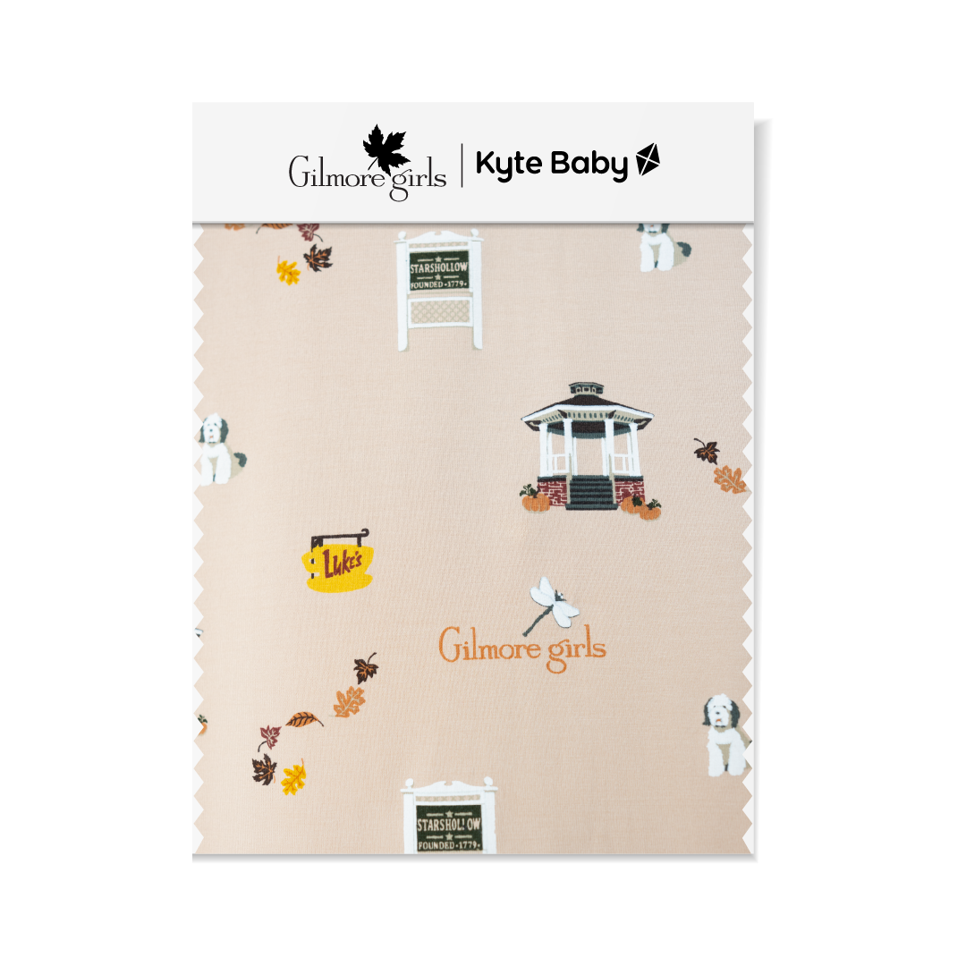 GIlmore Girls Fabric swatch featuring Stars Hallow sign, gazebo, Lukes coffee sign, fall leaves, Gilmore Girls logo and a white and grey dog.