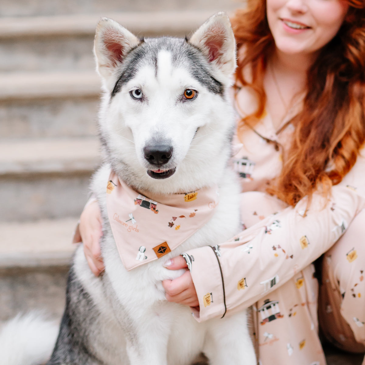 Female model wearing the long sleeve women's pajama set in gilmore girls sitting on stairs beside a husky wearing the Dog Bandana in Gilmore Girls