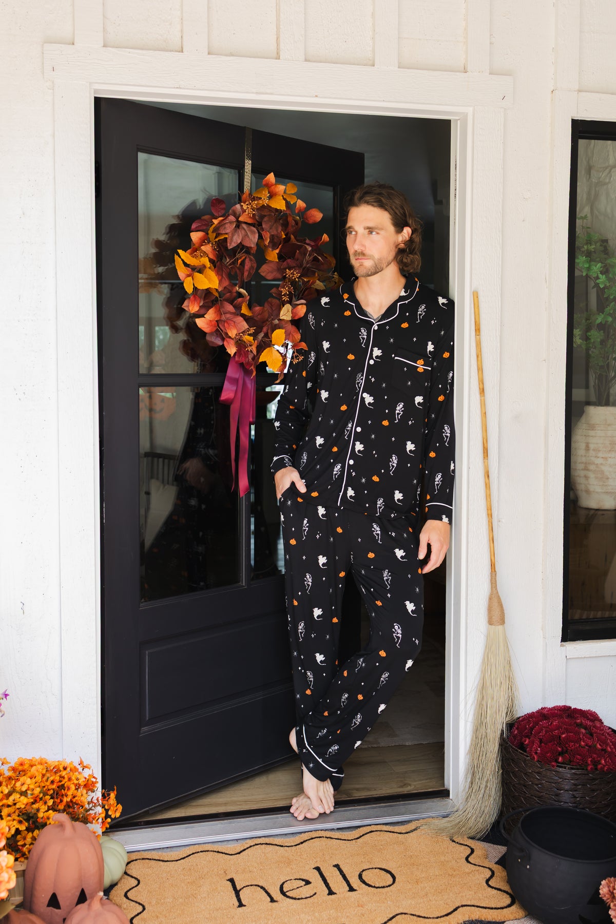 Model posing in Men's Long Sleeve Pajama Set in Halloween Friends print standing in doorway 