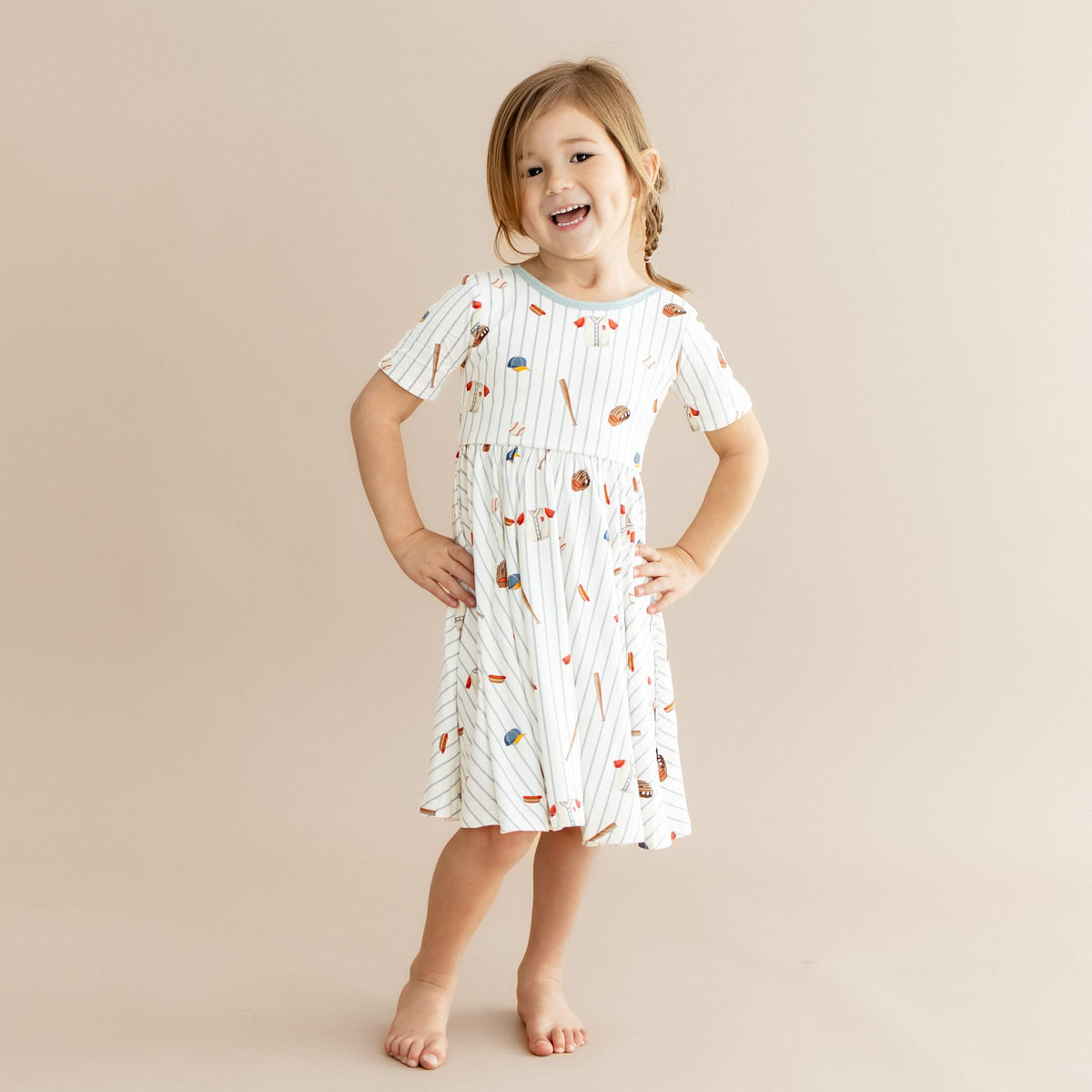 Young girl posing wearing the Twirl Dress in Home Run