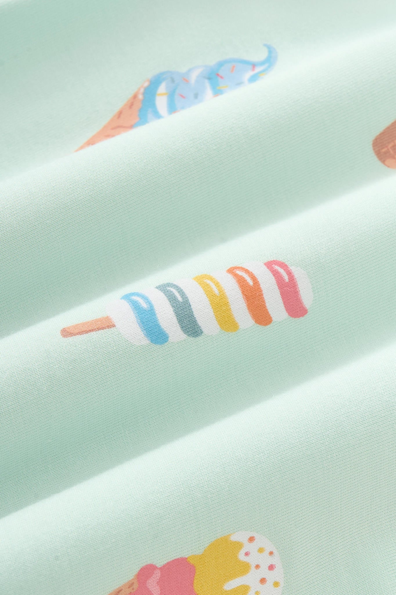Close up of colorful Ice cream print on green fabric