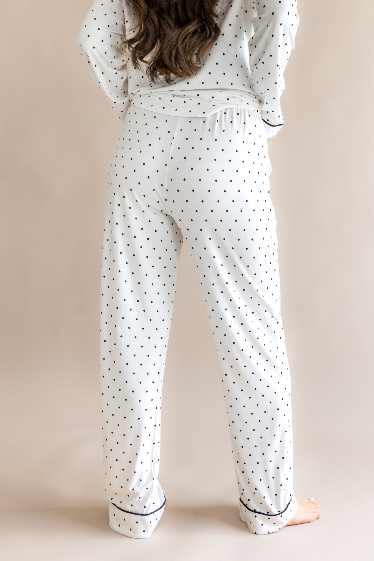 Back side of Women's long sleeve pajama set in Midnight Polka Dot print on a beige background