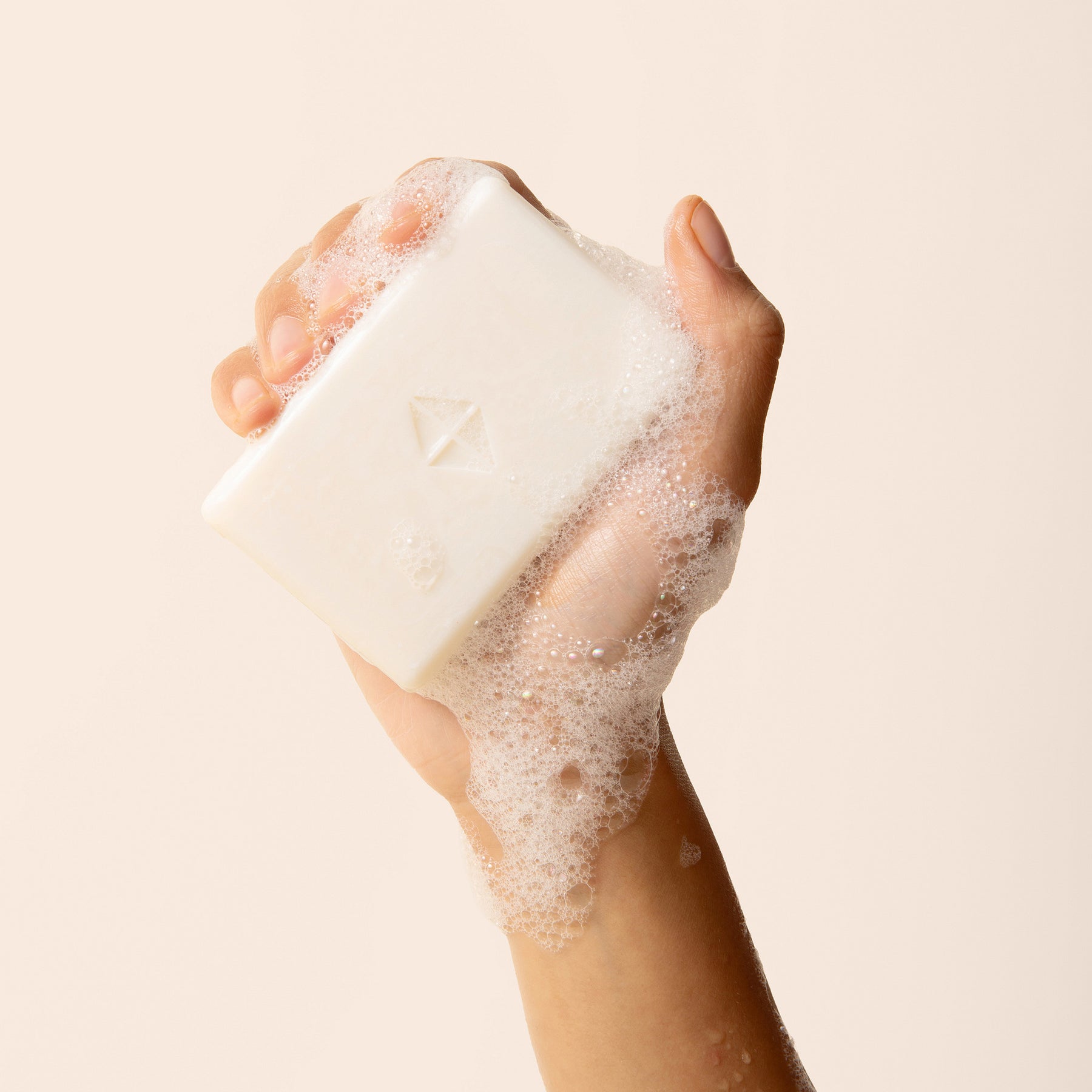 Bar of soap with Kyte Skin logo being held by a hand 