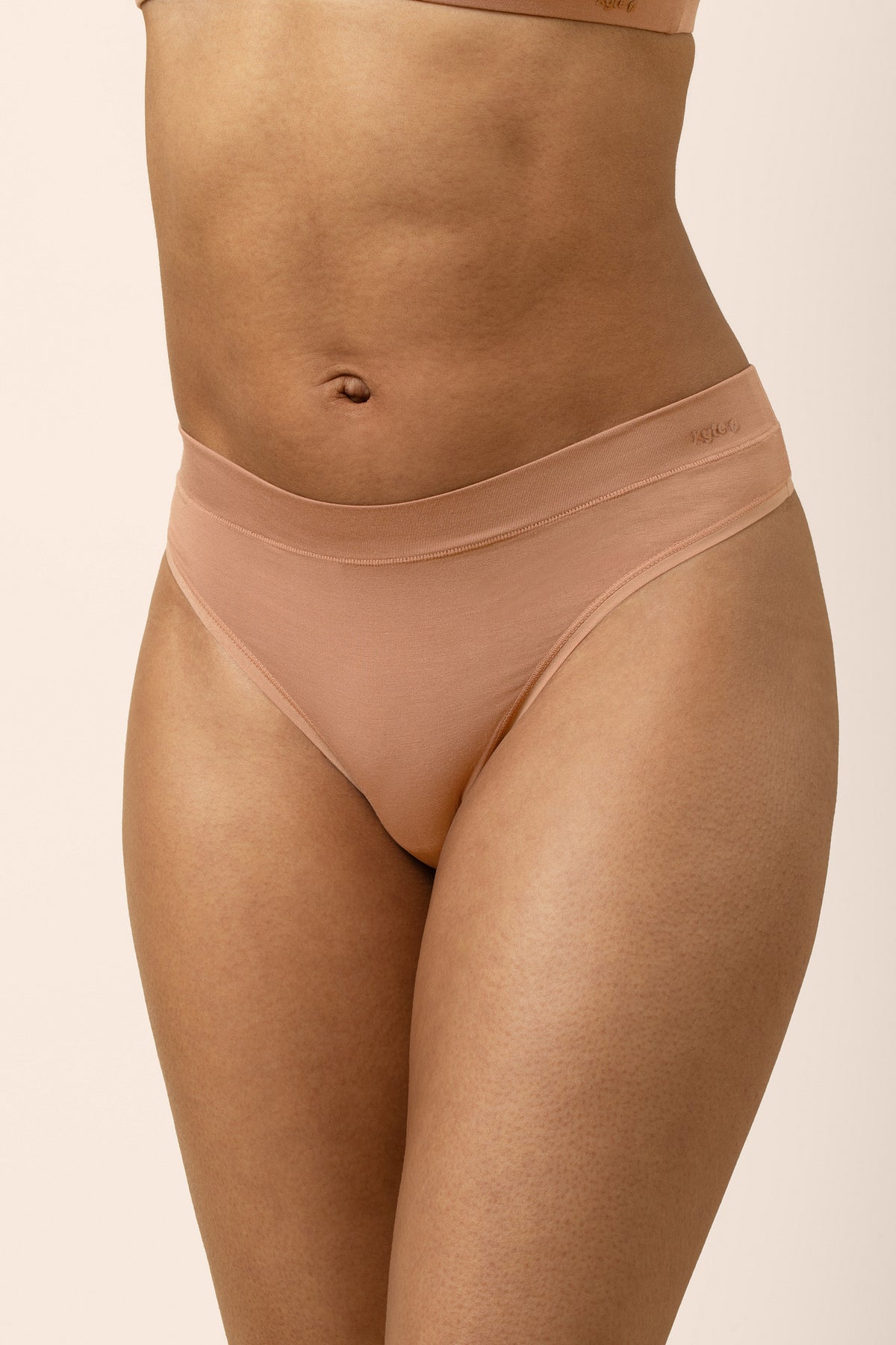 The front of the Women's Thong in Latte on a female model