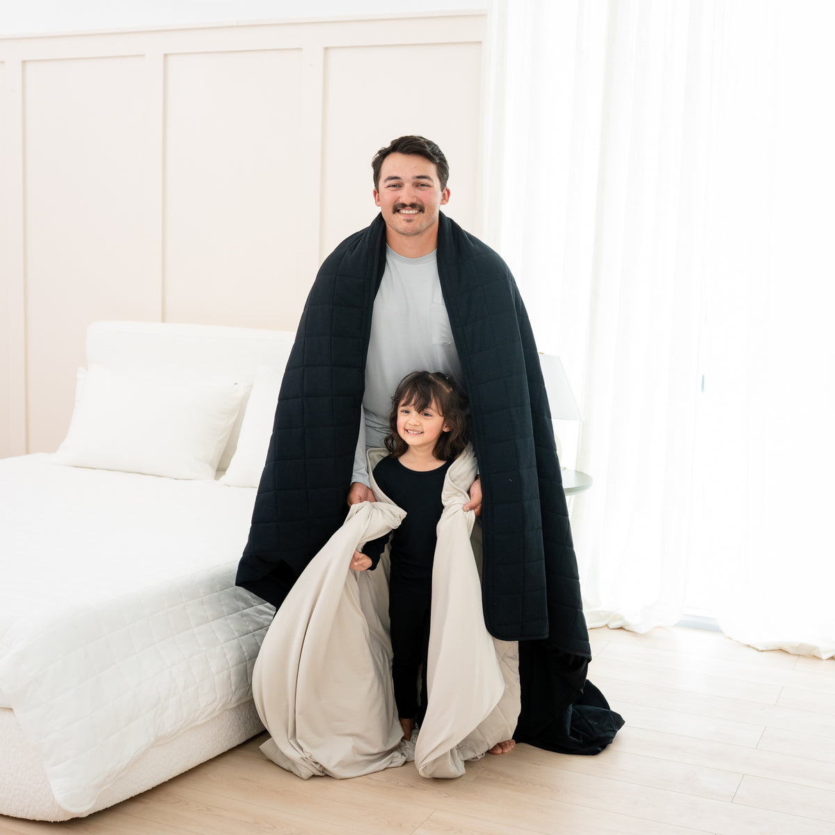 Man wrapped in Adult Quilted Blanket in Midnight 1.0 with toddler 