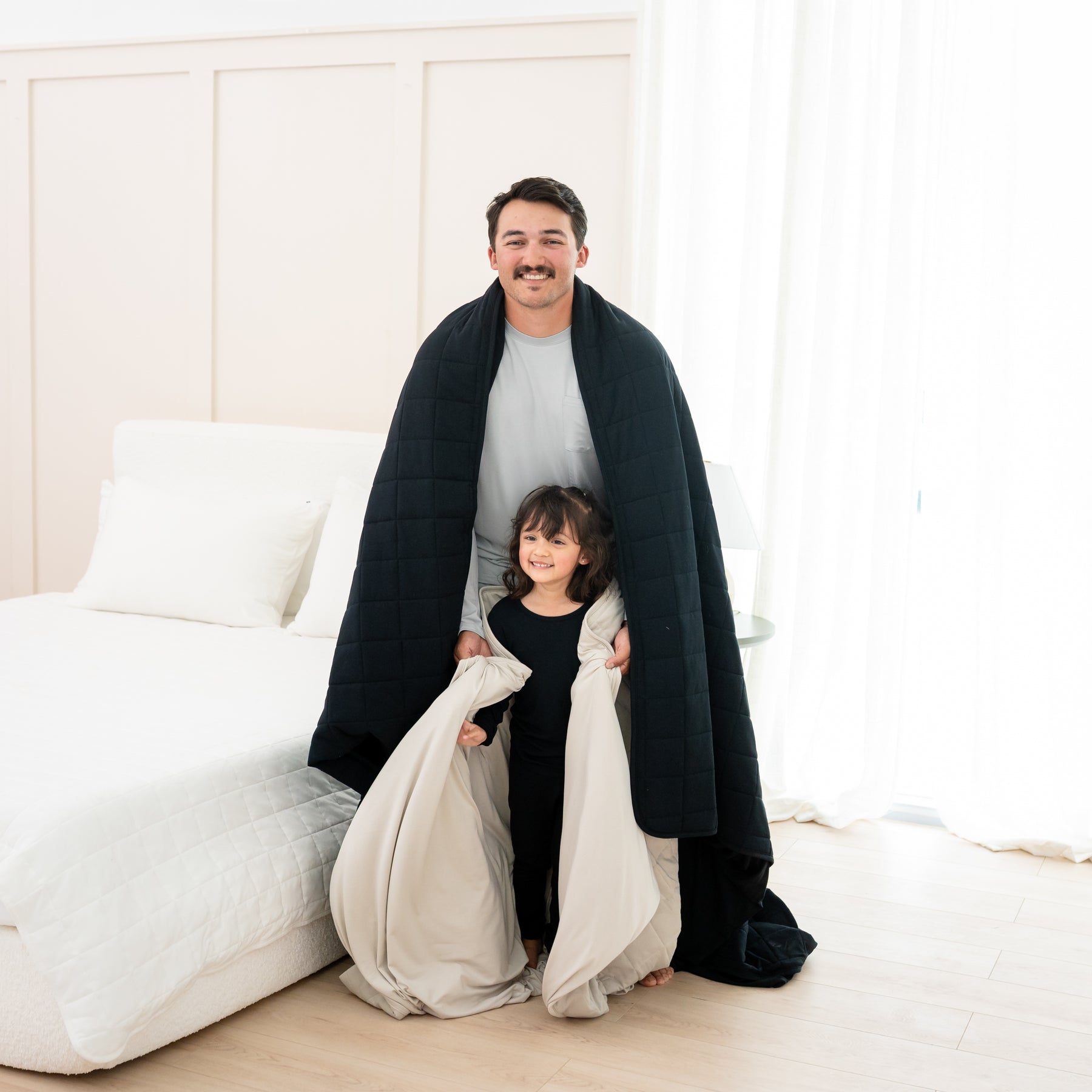 Man wrapped in Adult Quilted Blanket in Midnight 1.0 with toddler 