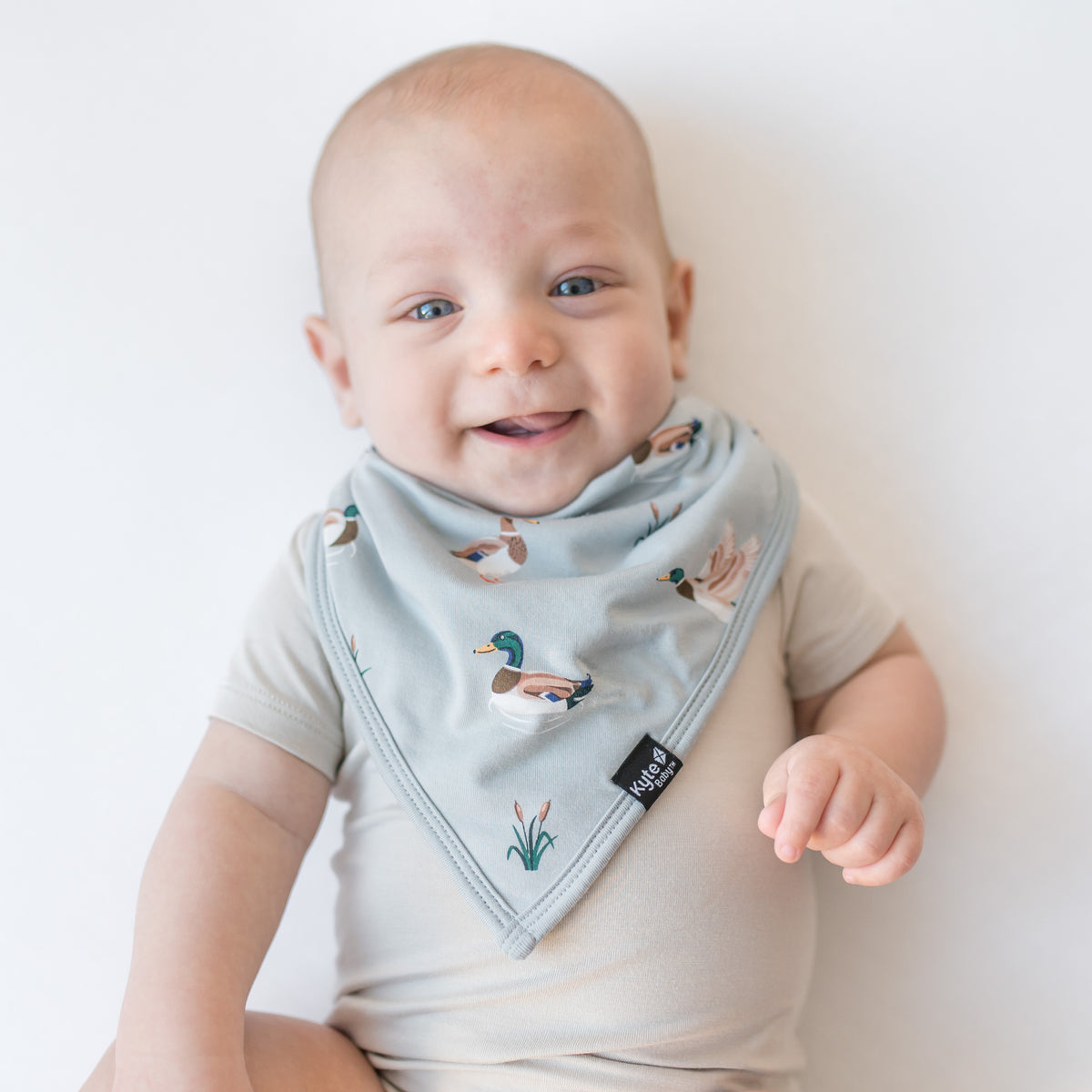 Close up of an infant wearing the Bib in Mallard Duck