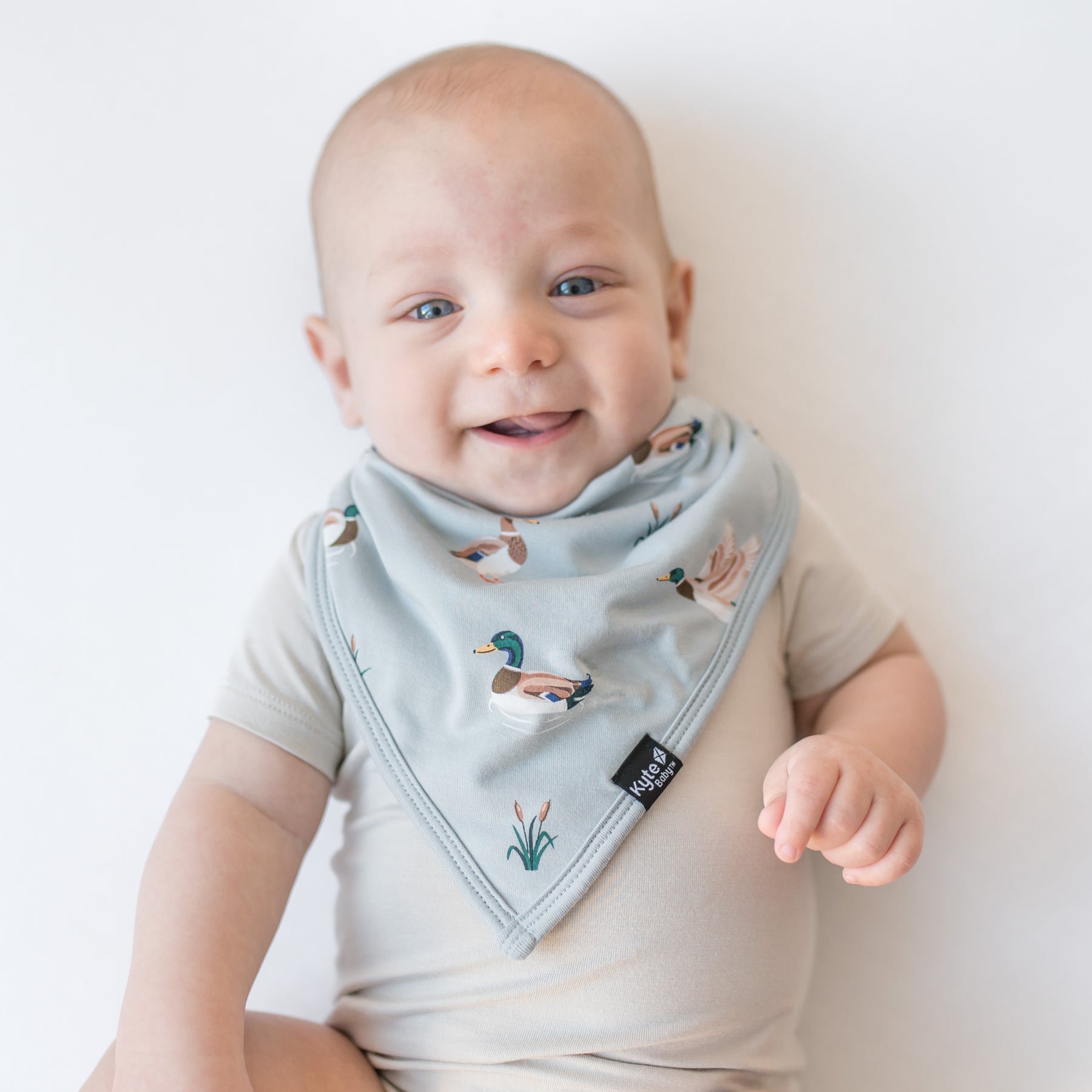 Close up of an infant wearing the Bib in Mallard Duck