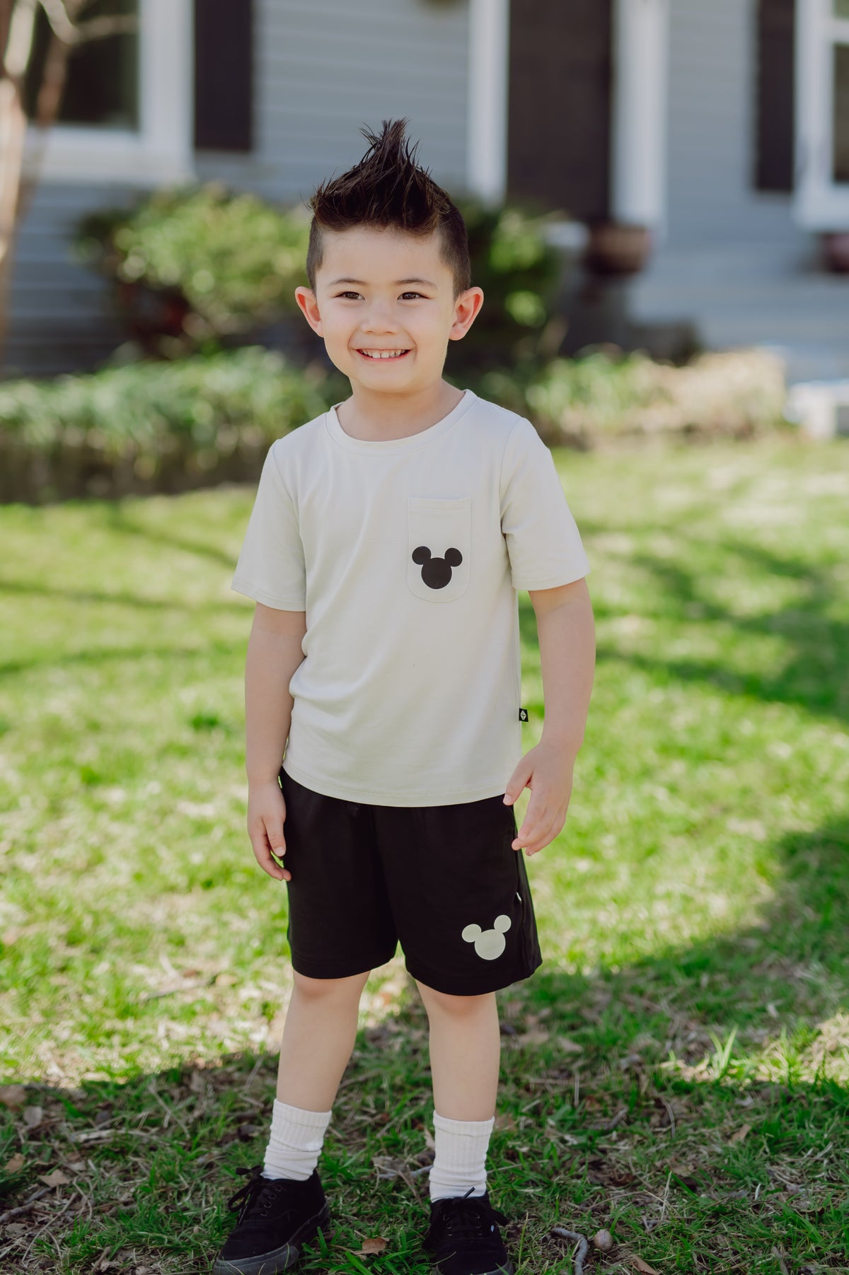 Child wearing mickey tshirt and shorts outdoors