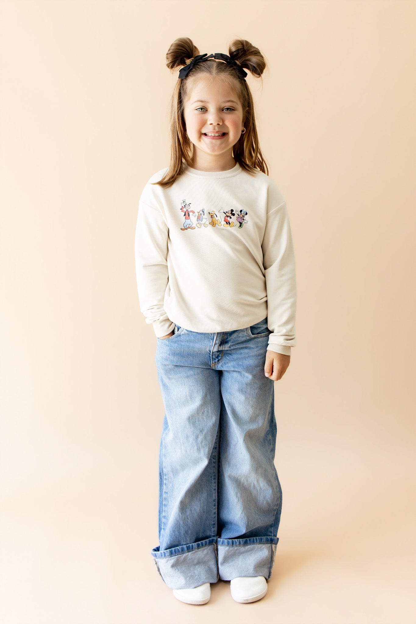 Young girl in mickey and friends sweatshirt and jeans