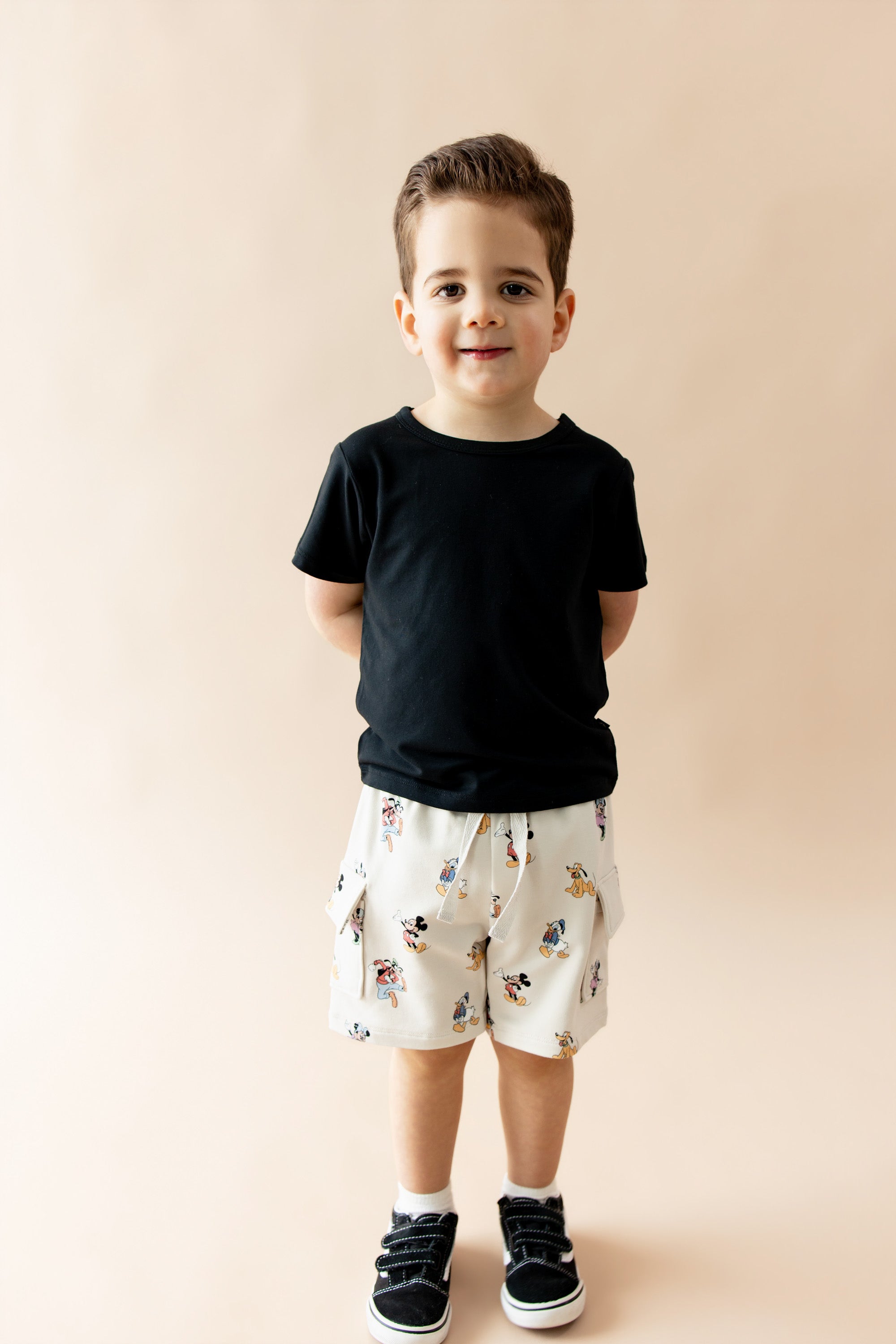 Boy wearing black tshirt and mickey mouse and friends printed cargo shorts