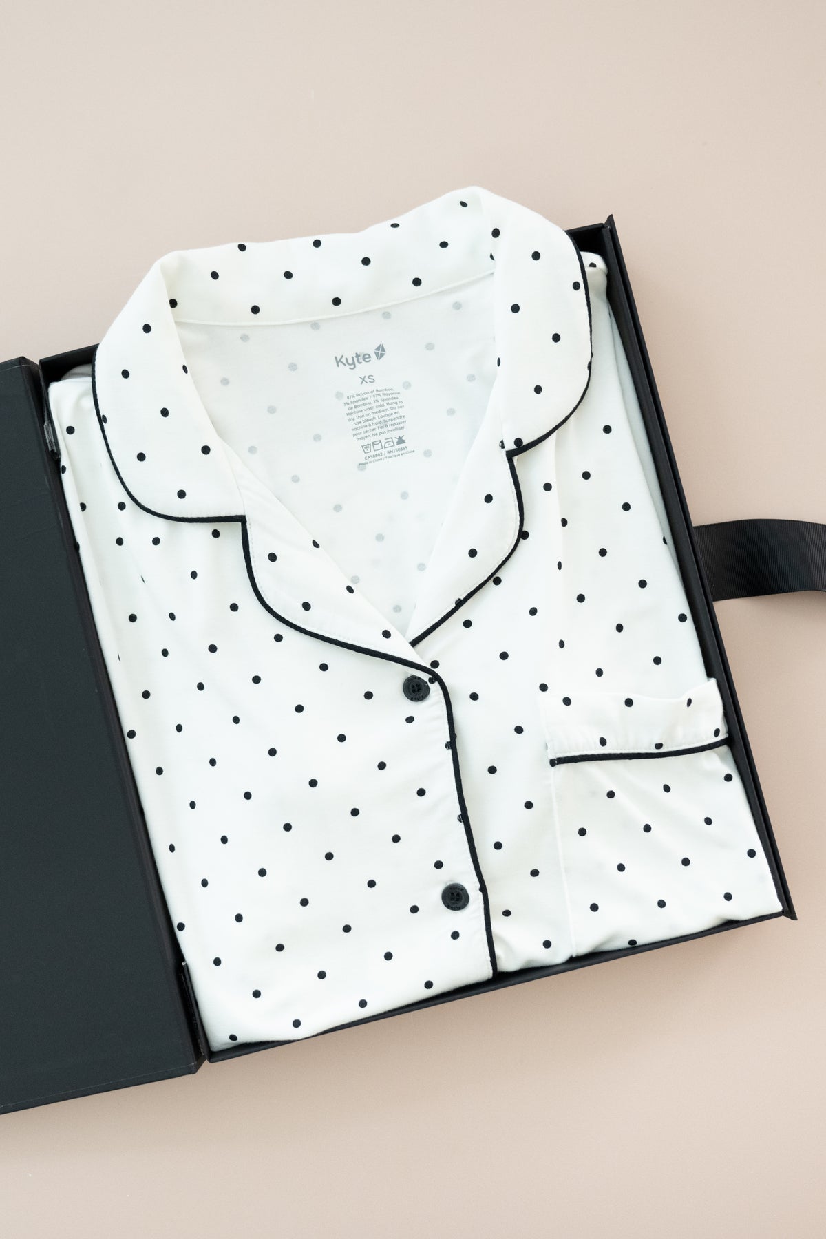 Long-Sleeved Women's Pajama Set in Midnight Polka Dot print packed in a box on a beige background