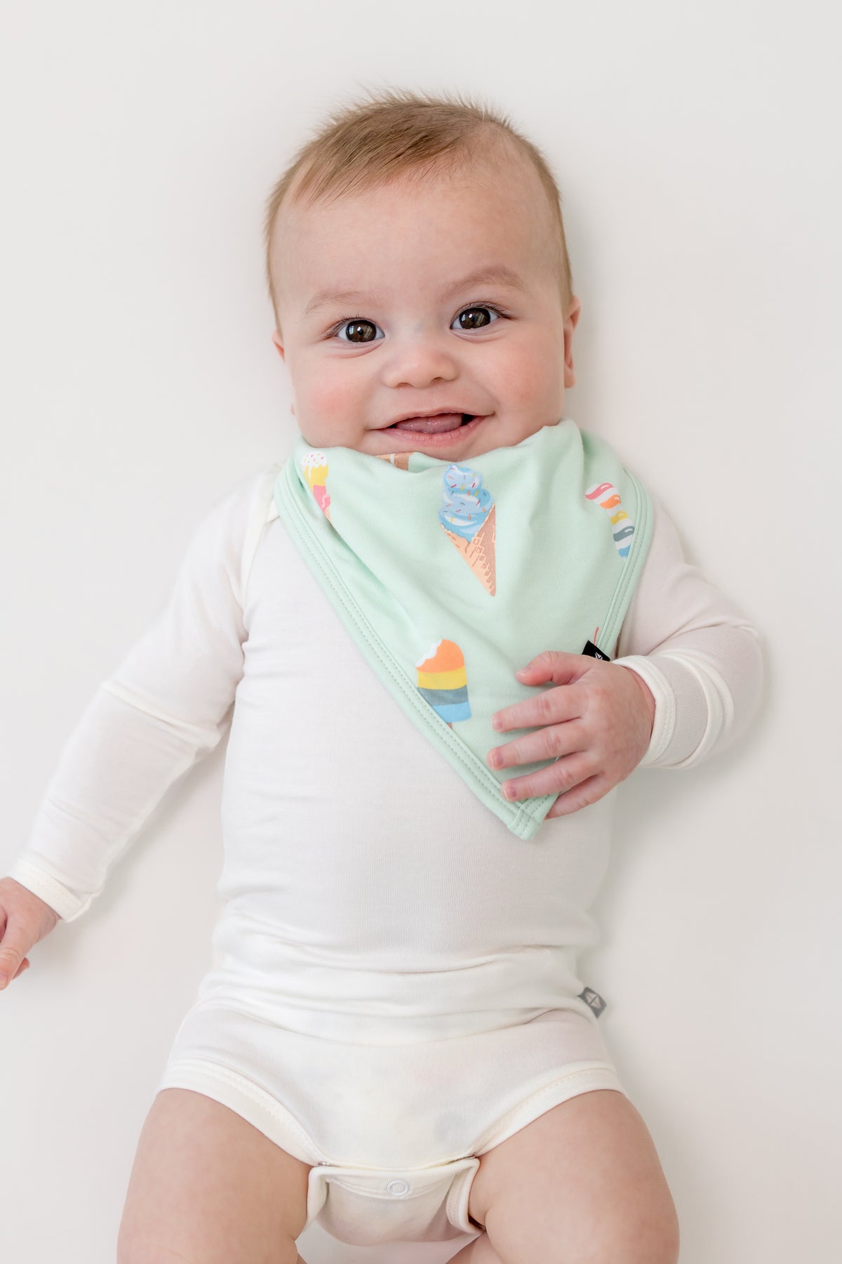 Baby wearing Mint Ice cream print Bib over a white bodysuit on a white background
