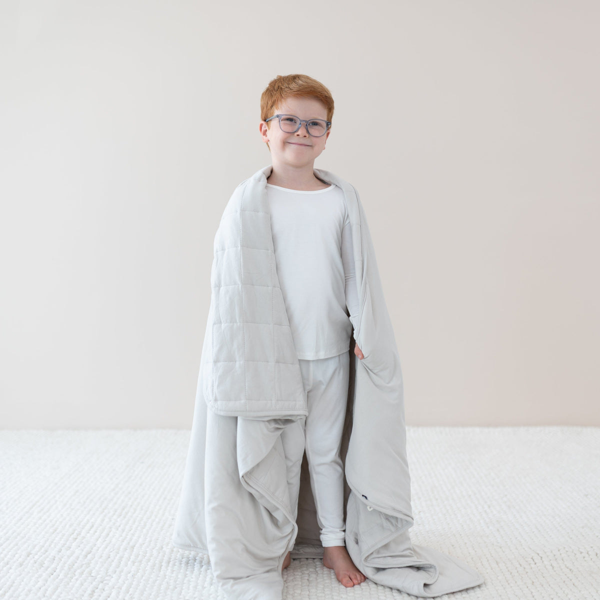 Child  in cloud pajamas wrapped in Youth Blanket in Oat 1.0
