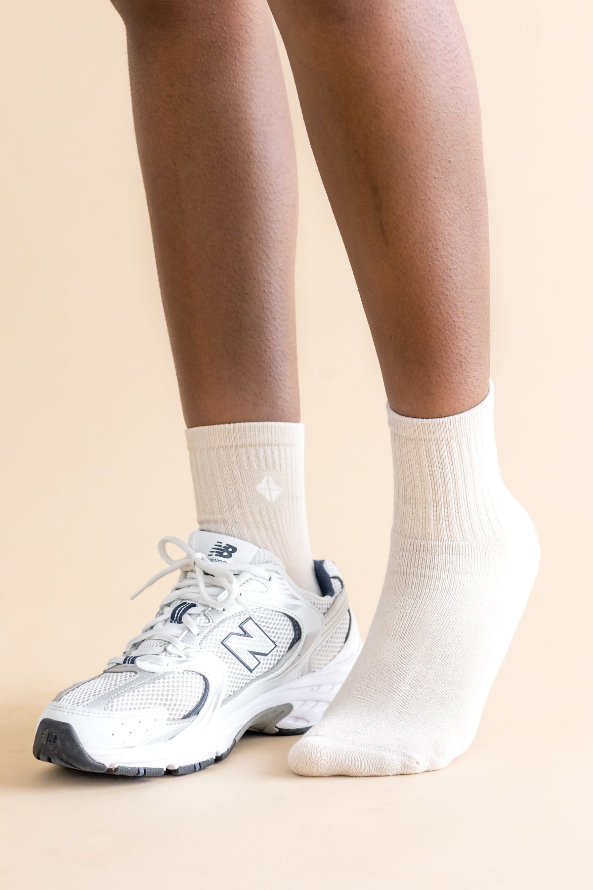 Adult Crew Socks in Oat shown on  models feet with a sneaker on the right foot
