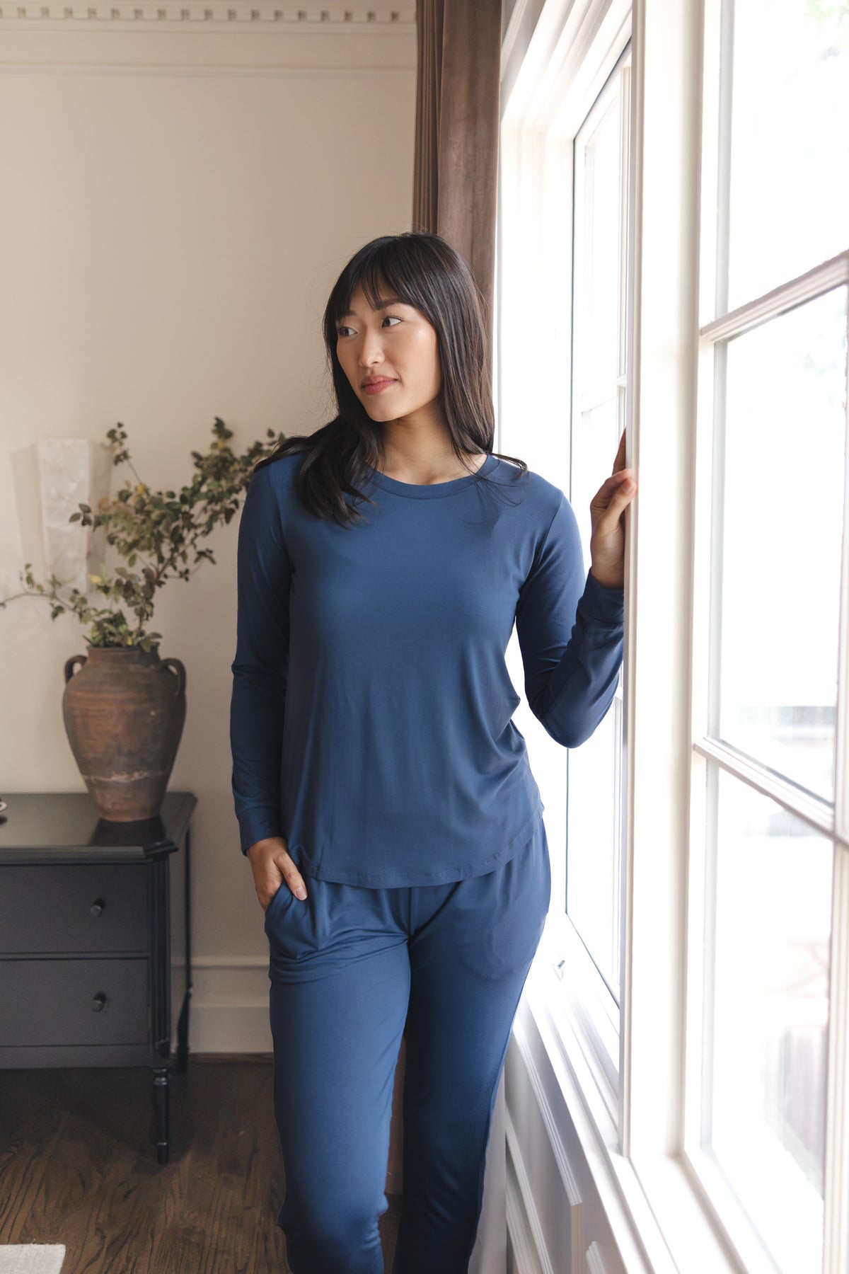 Modal posing in Women's Jogger Pajama Set in Oxford standing near a glass window