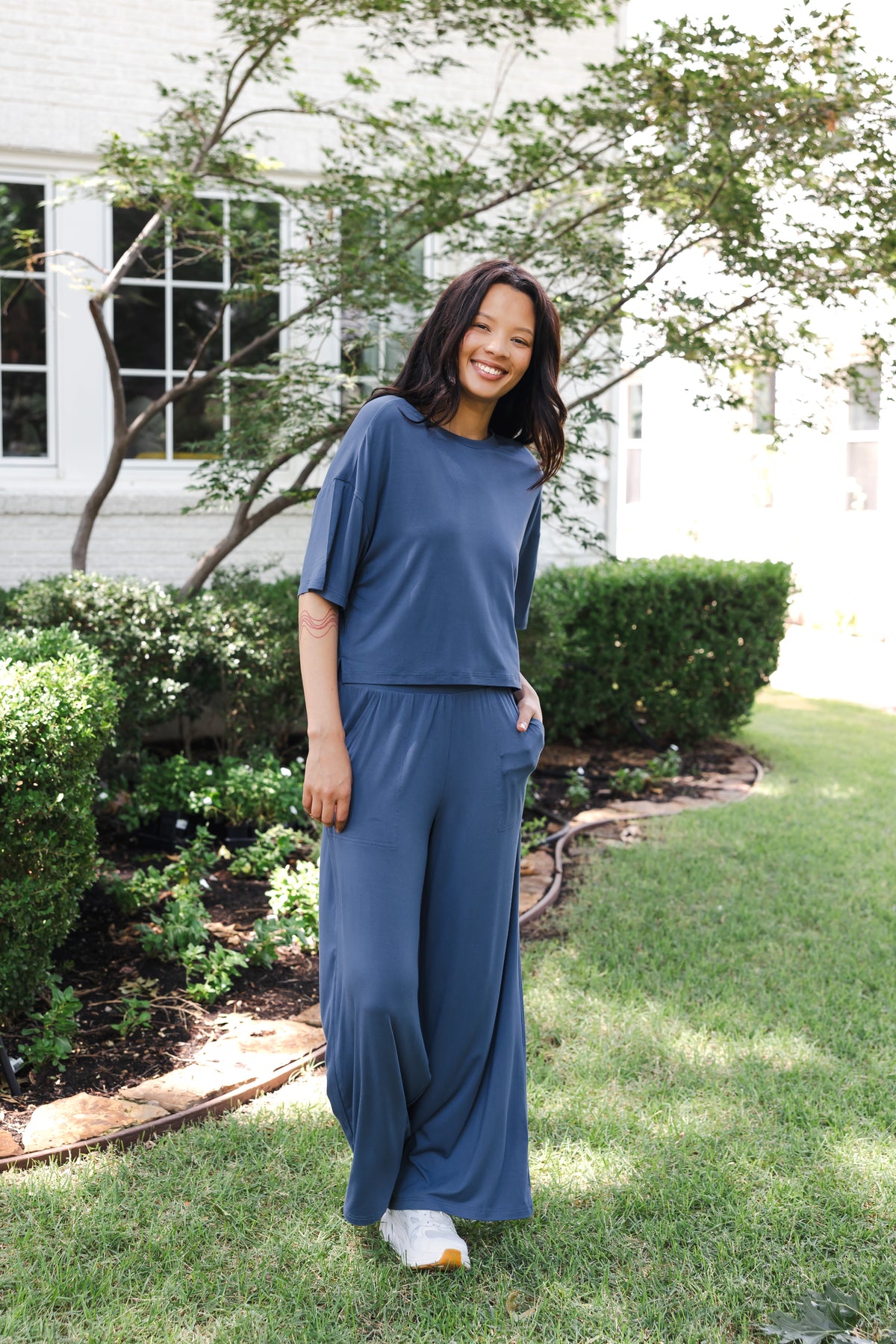 Modal wearing Women's Wide Leg Pant in Oxford standing outdoors in a garden