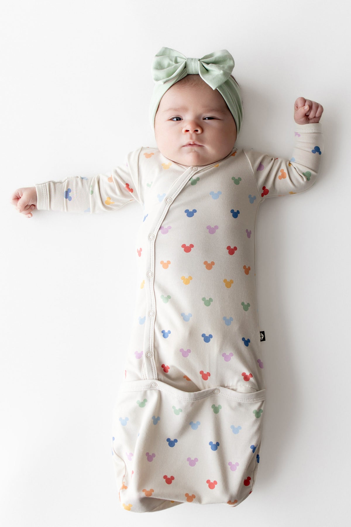 Baby in Mickey Mouse head printed bundler with button closure and light green bow 