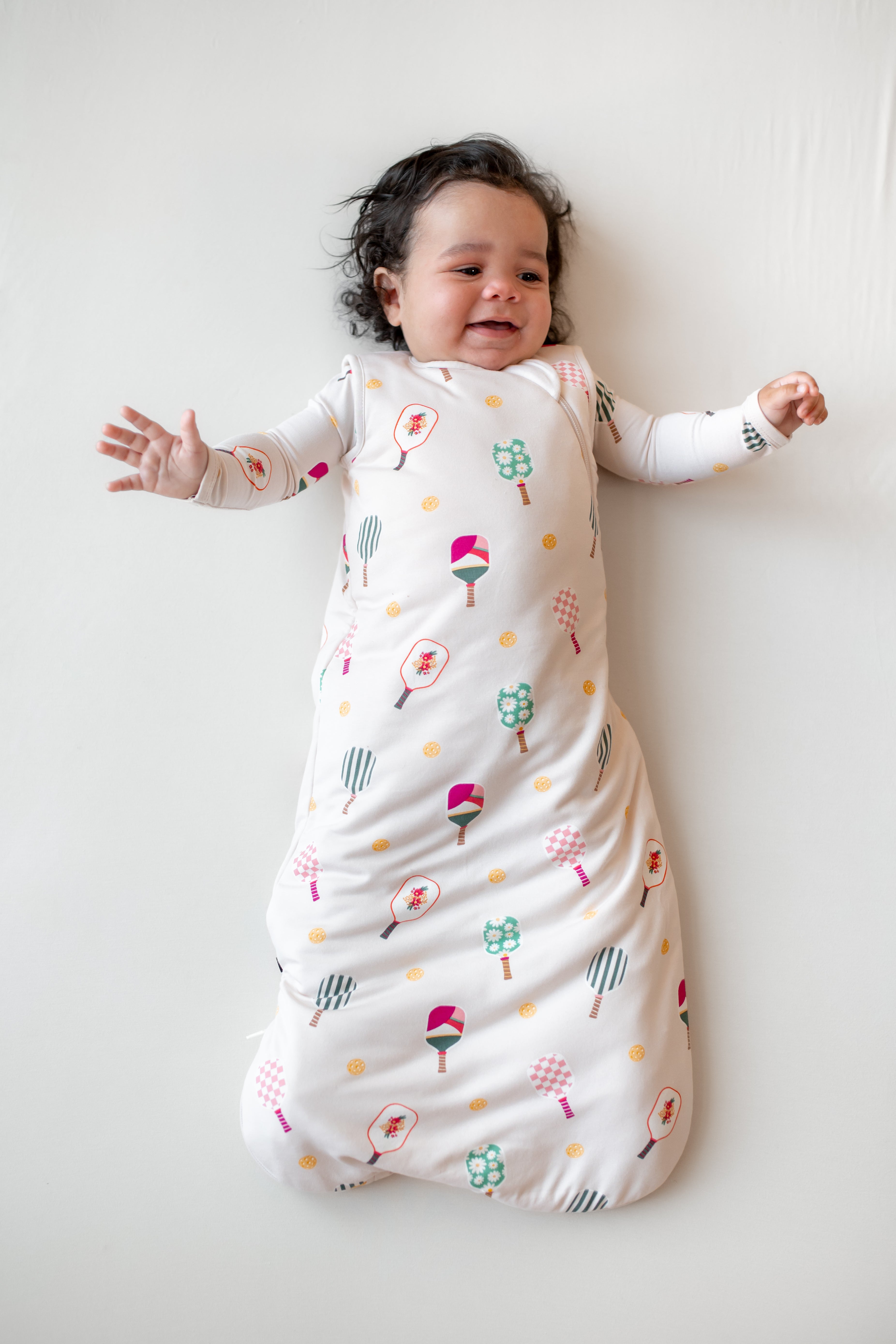 Baby in Sleep Bag in Pickleball 1.0 print on a beige background