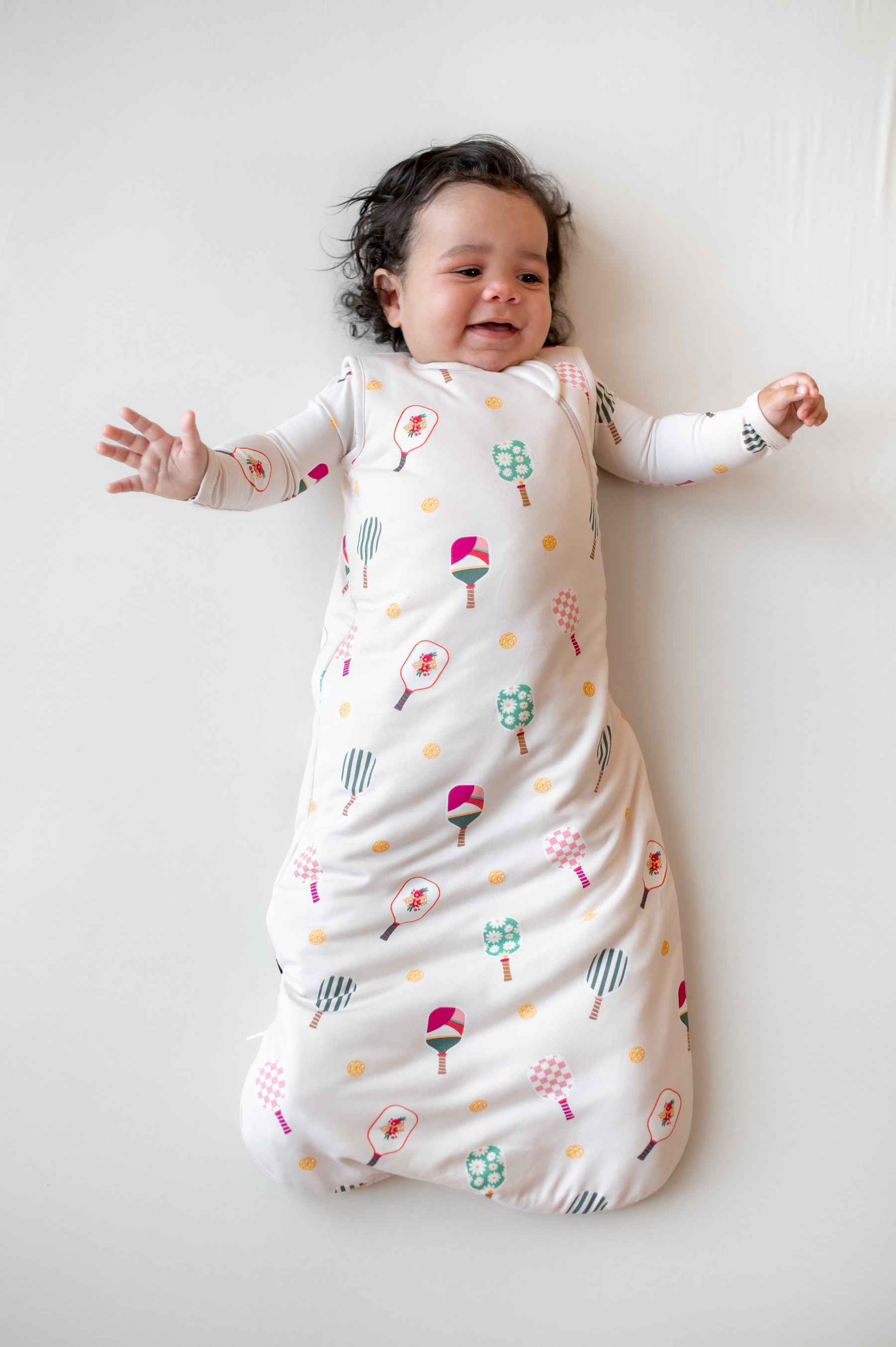 Baby in Sleep Bag in Pickleball 1.0 print on a beige background