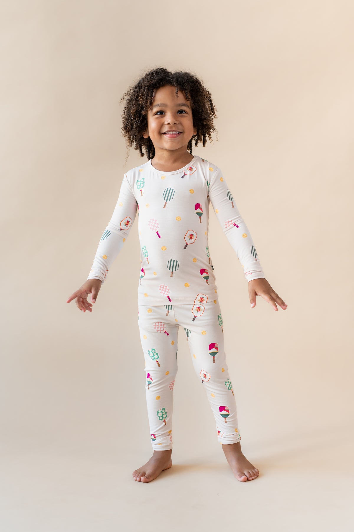 Girl posing in Long Sleeve Pajamas in Pickleball print standing on pickleball court