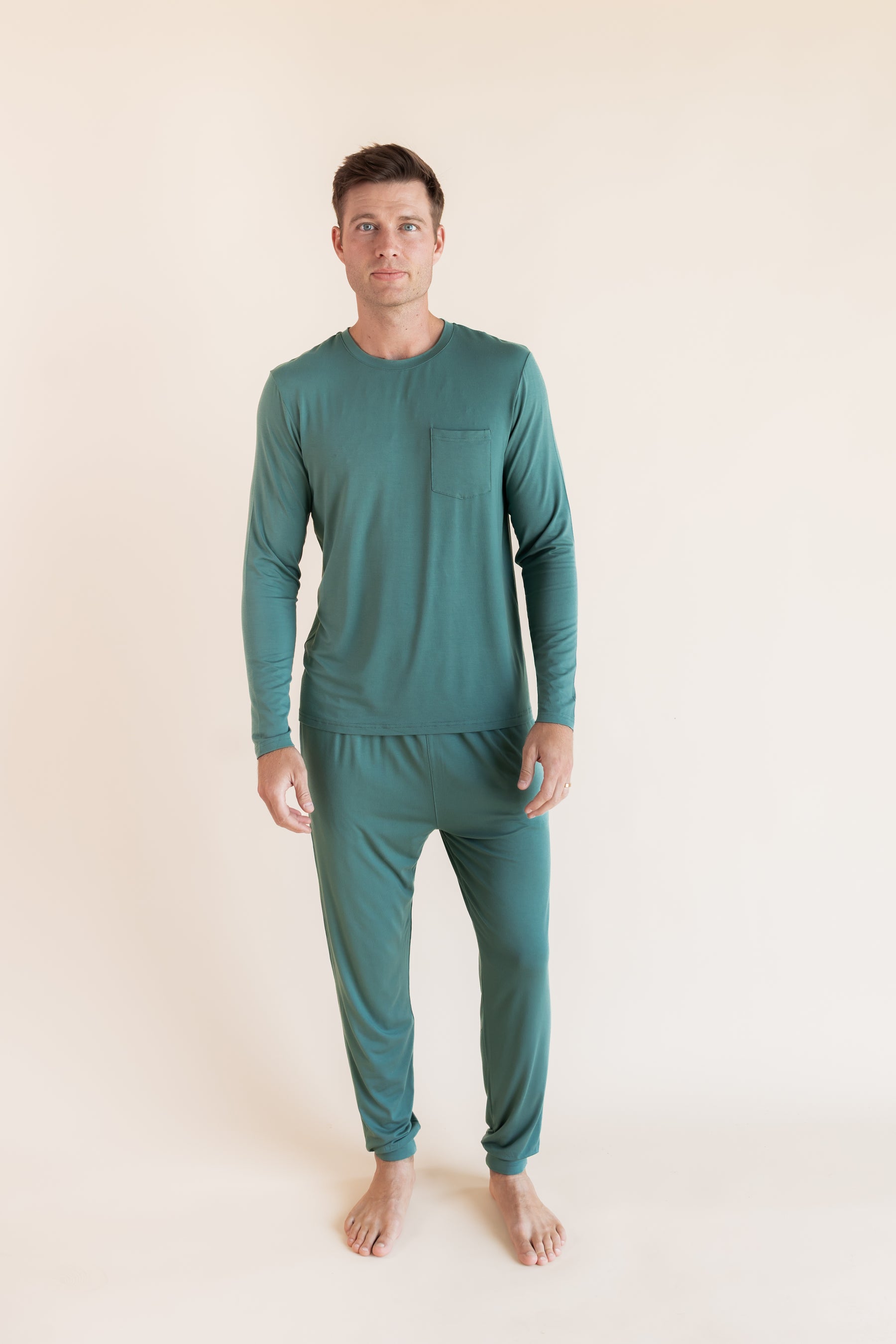 Model wearing Men's Jogger Set in Pine on a beige background