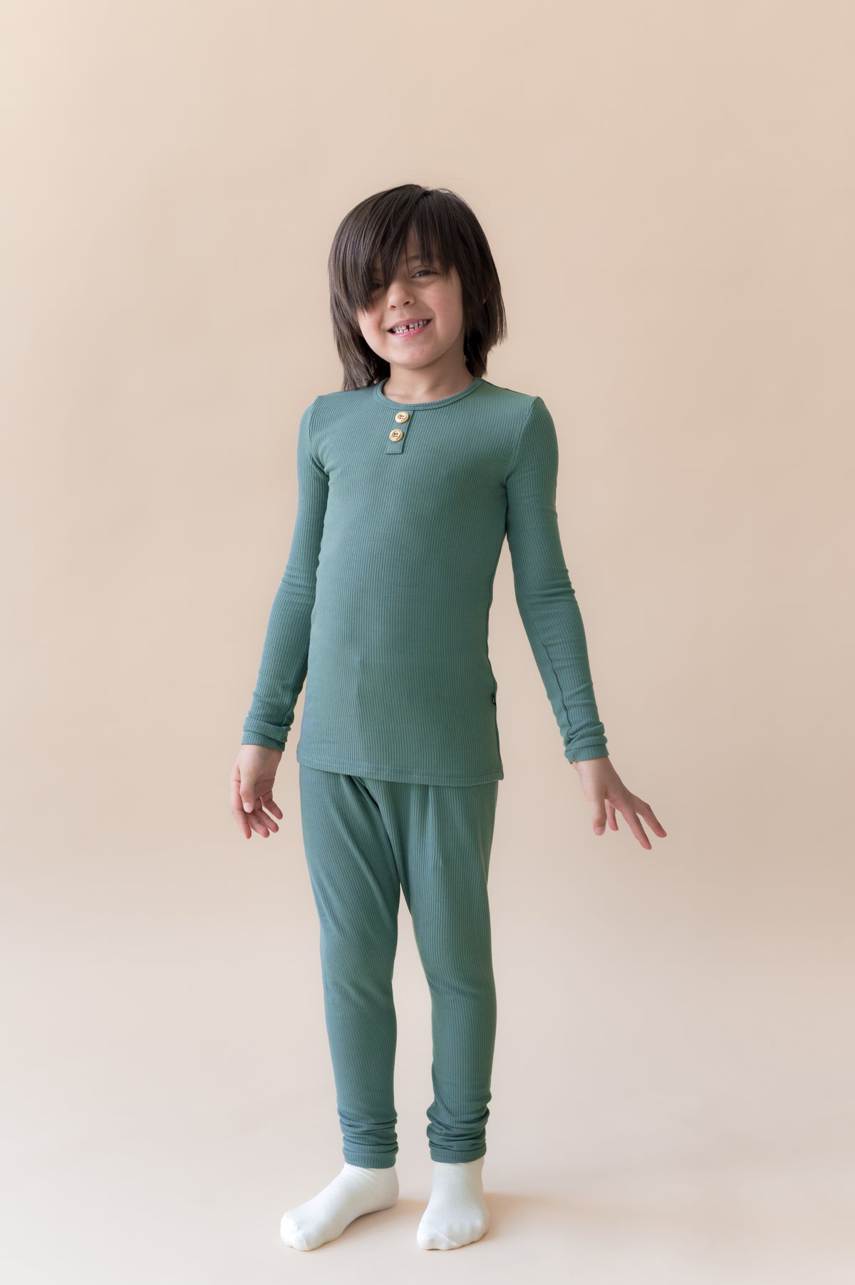 Boy posing in Ribbed Henley Set in Pine on a white background