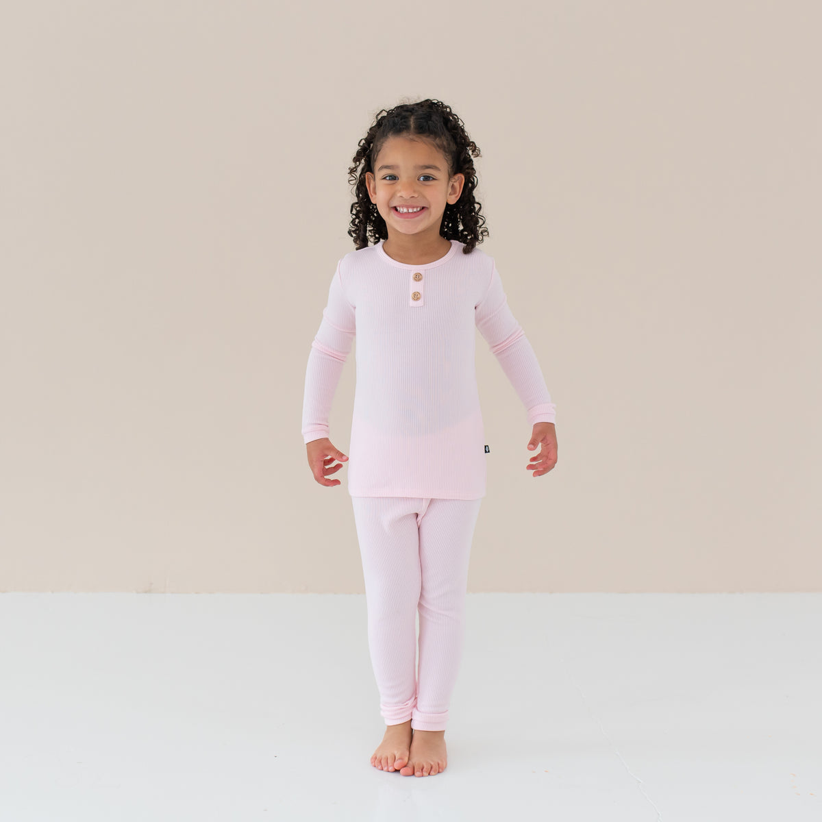 Toddler smiling modeling Ribbed Henley Set in Sakura