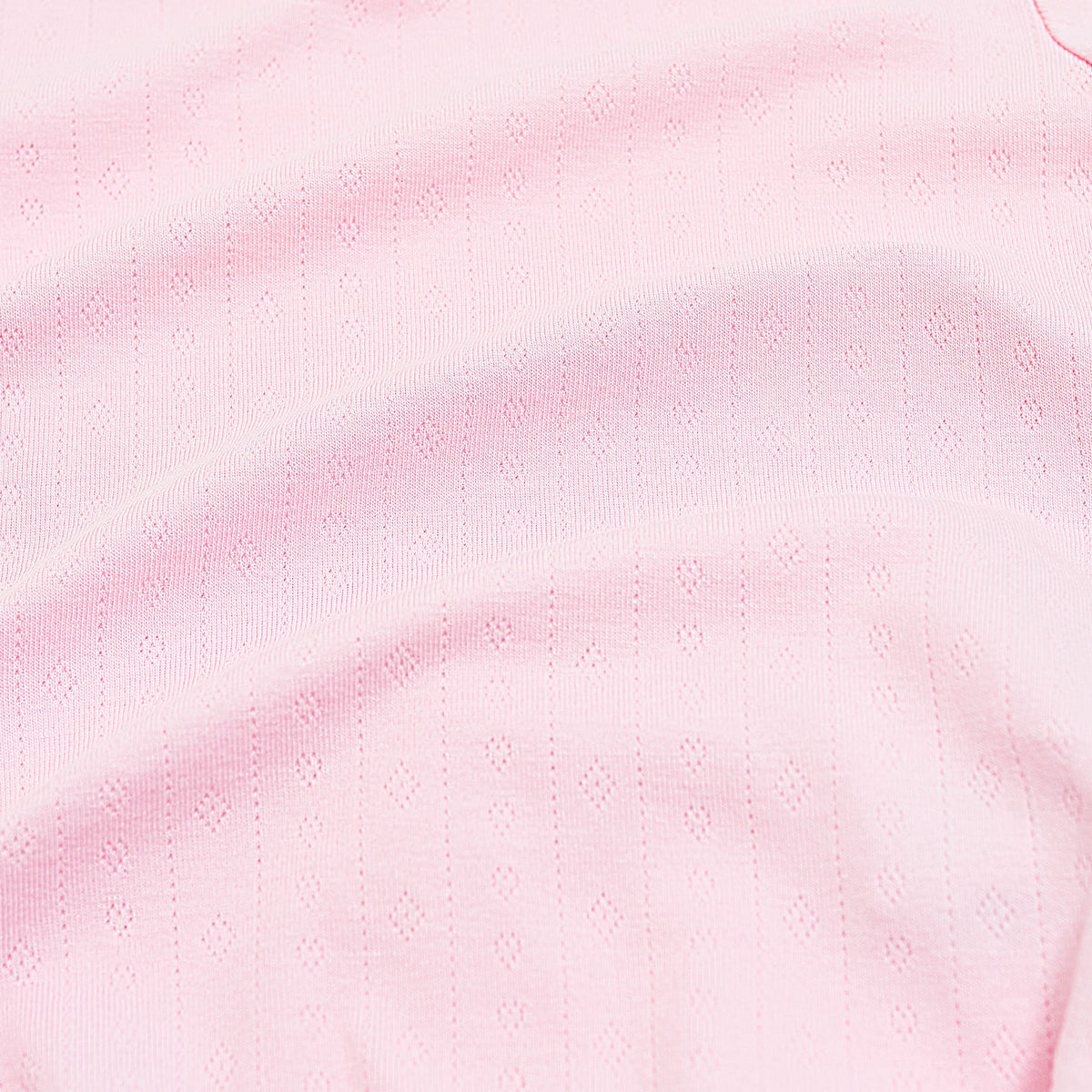 Close up of the pointelle fabric showing the light pink color