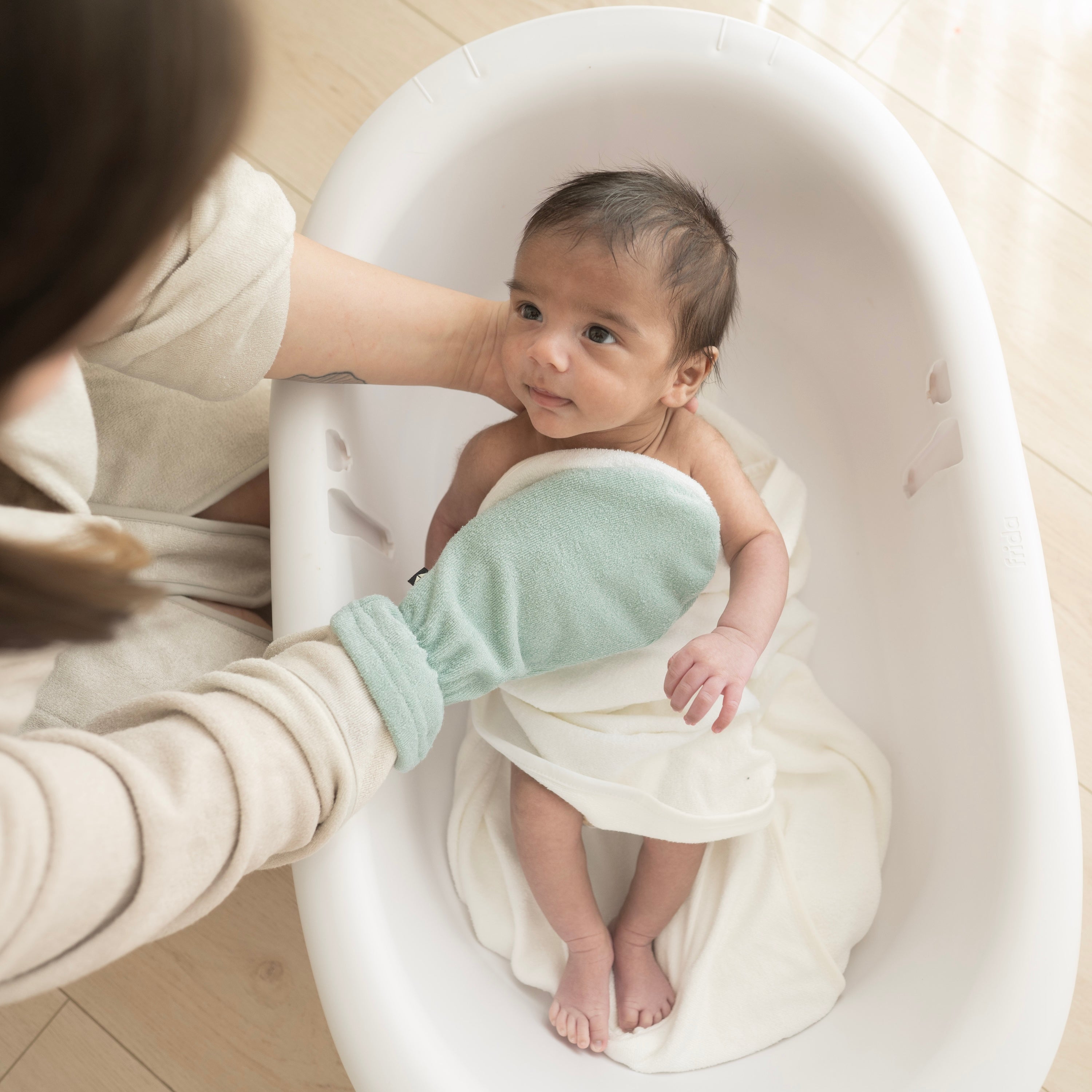 Mom using Bamboo Terry Bath Mitt in Sage Green to Bathe Newborn