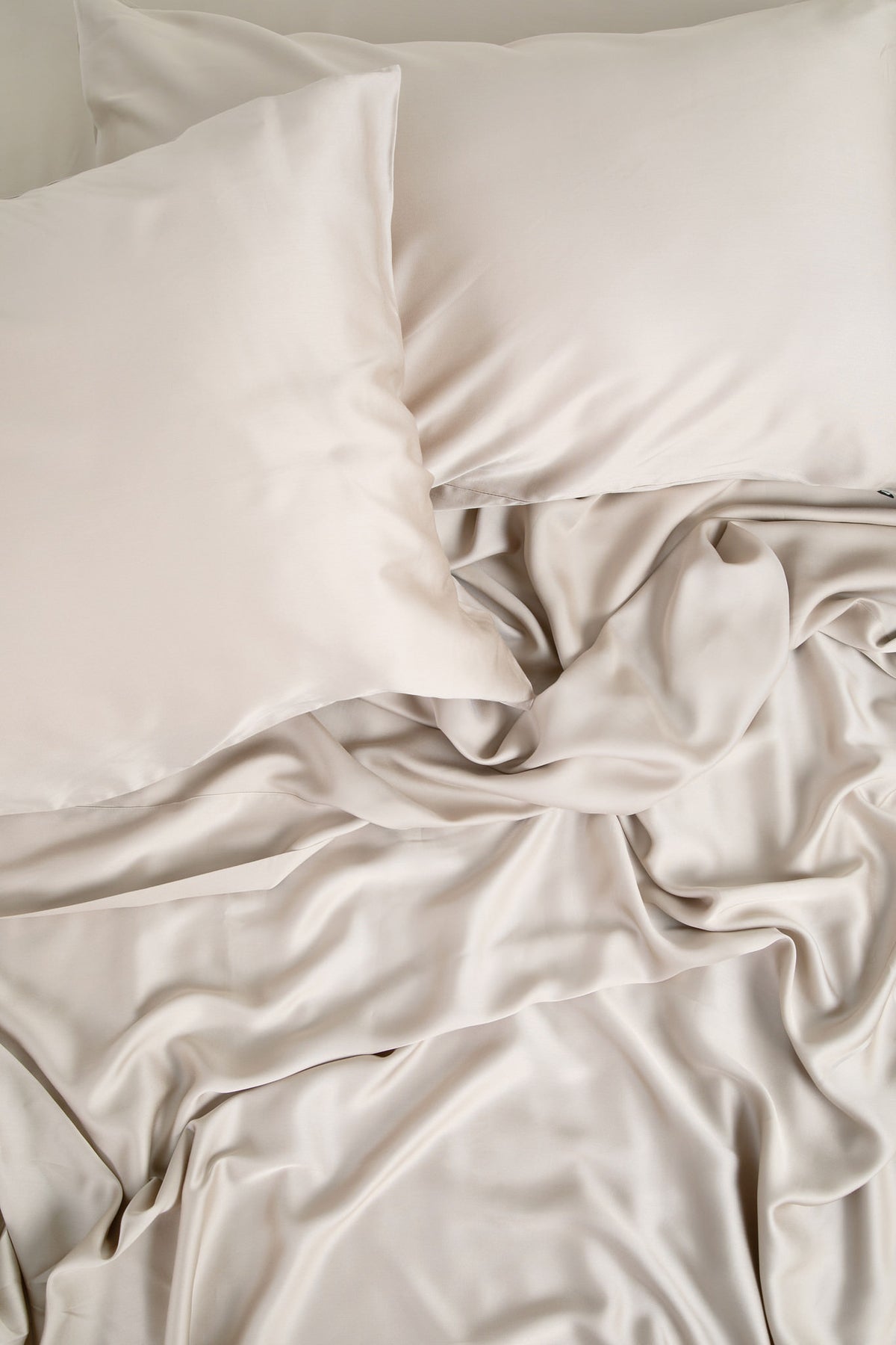 Bamboo Sateen Pillowcase Set in Sand Stone shown on a bed with matching bed sheets