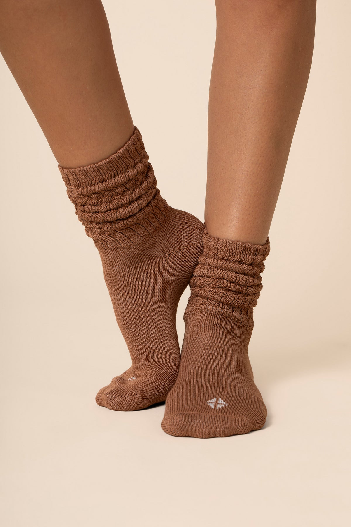 Brown ribbed socks worn by a person on a beige background