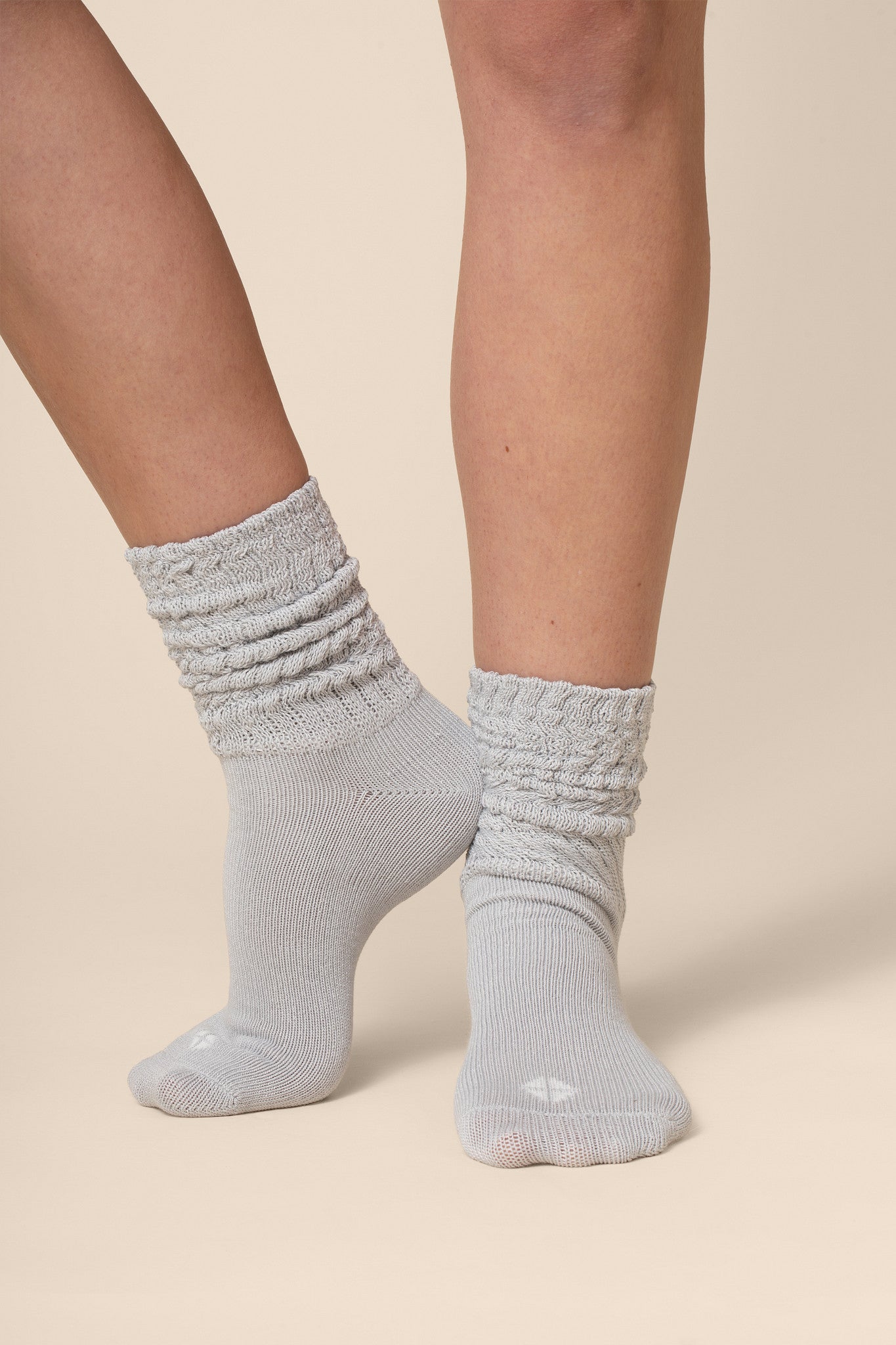 Gray socks worn by a person on a beige background