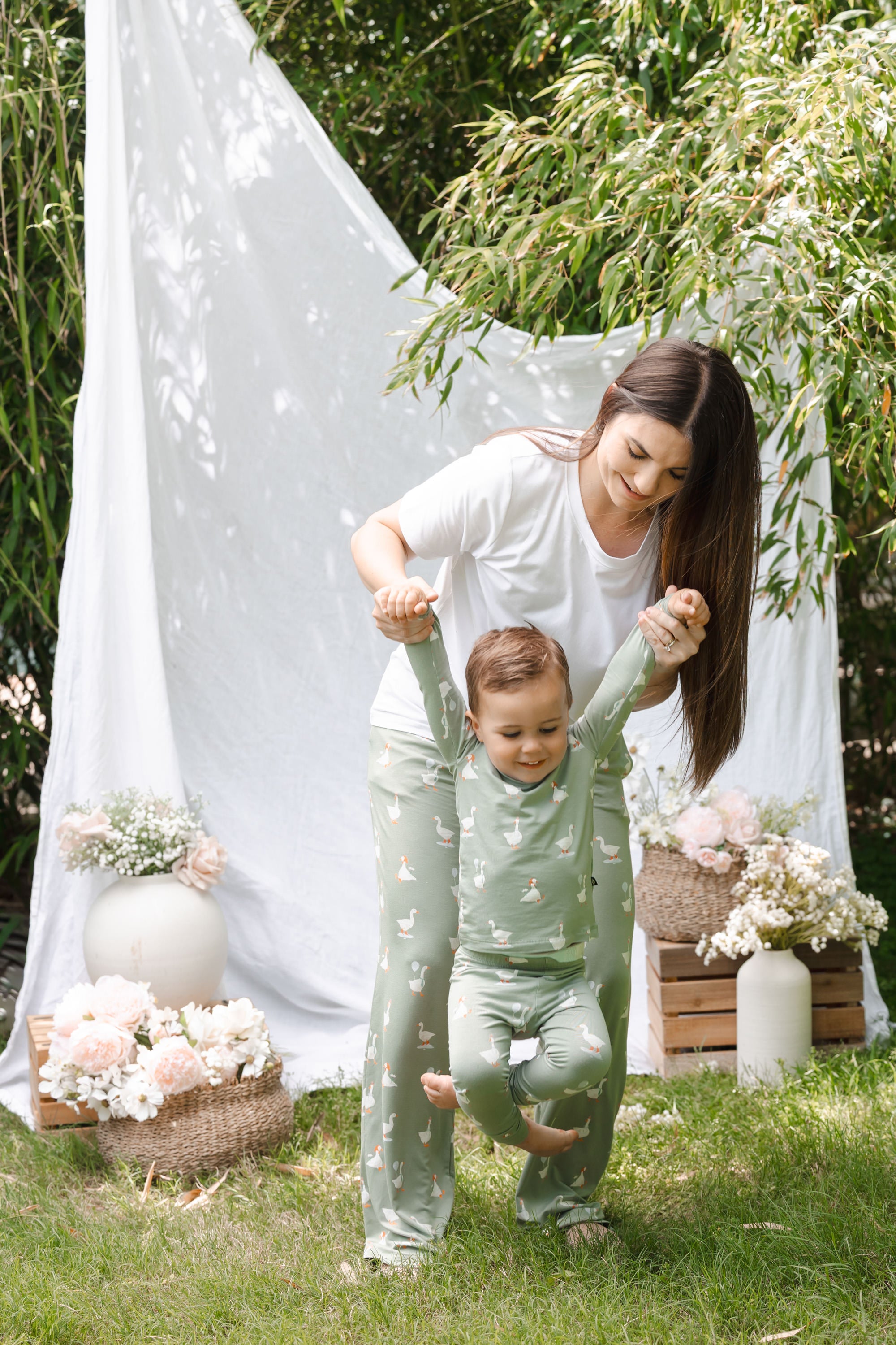 Mom and toddler playing outdoors wearing matching silly goose pajamas