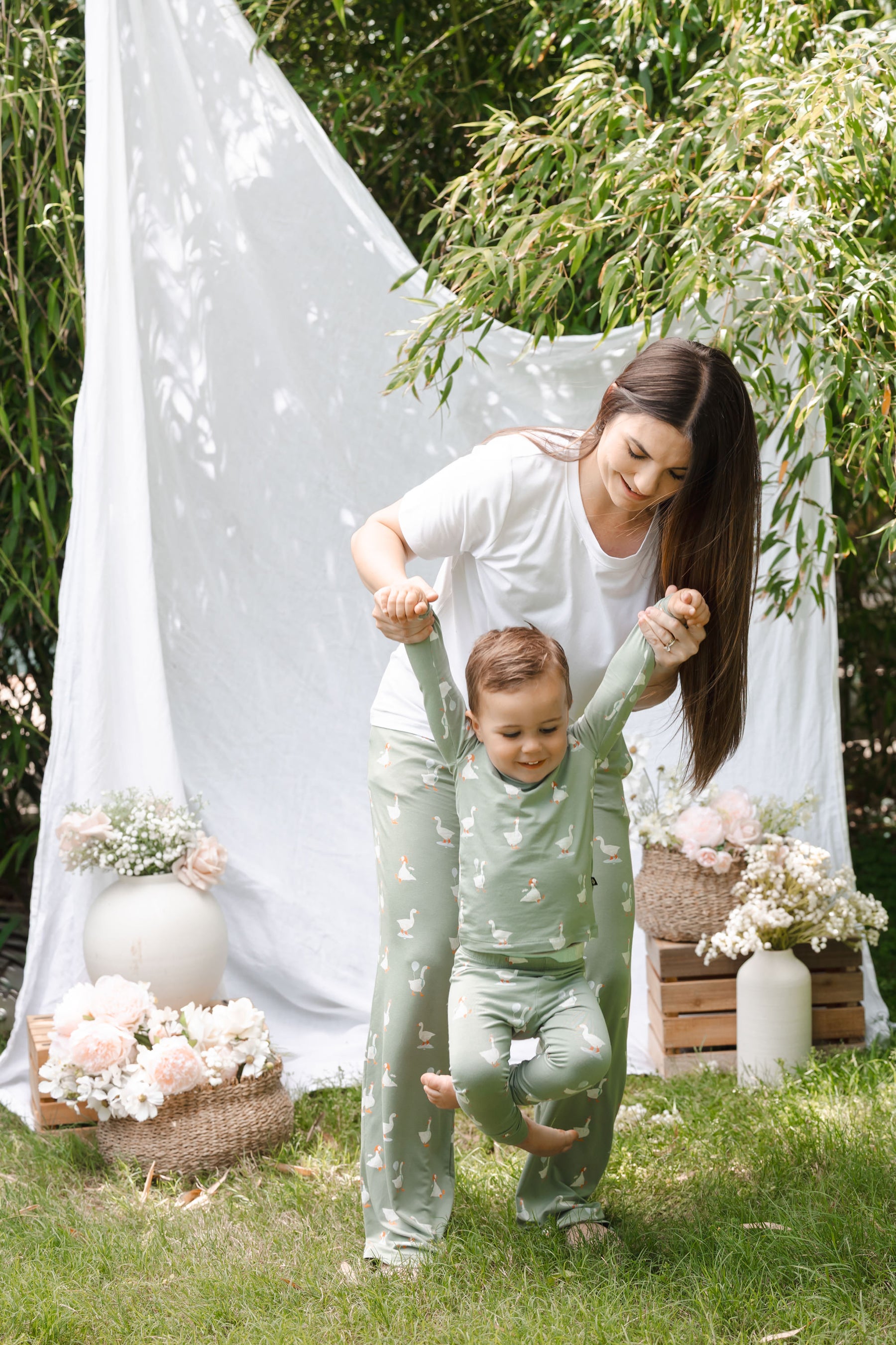 Mom and toddler playing outdoors wearing matching silly goose pajamas