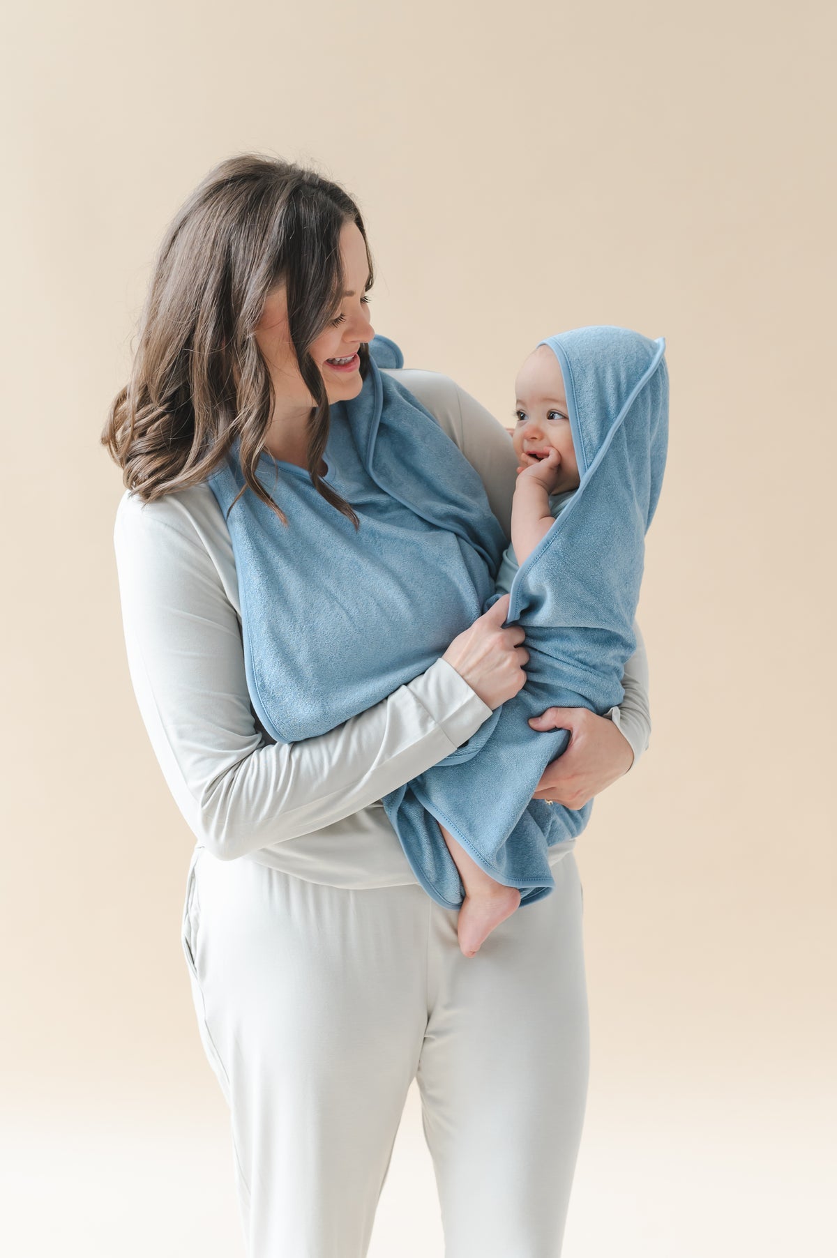 Mother holding her infant wrapped in the Terry Apron Towel in Slate