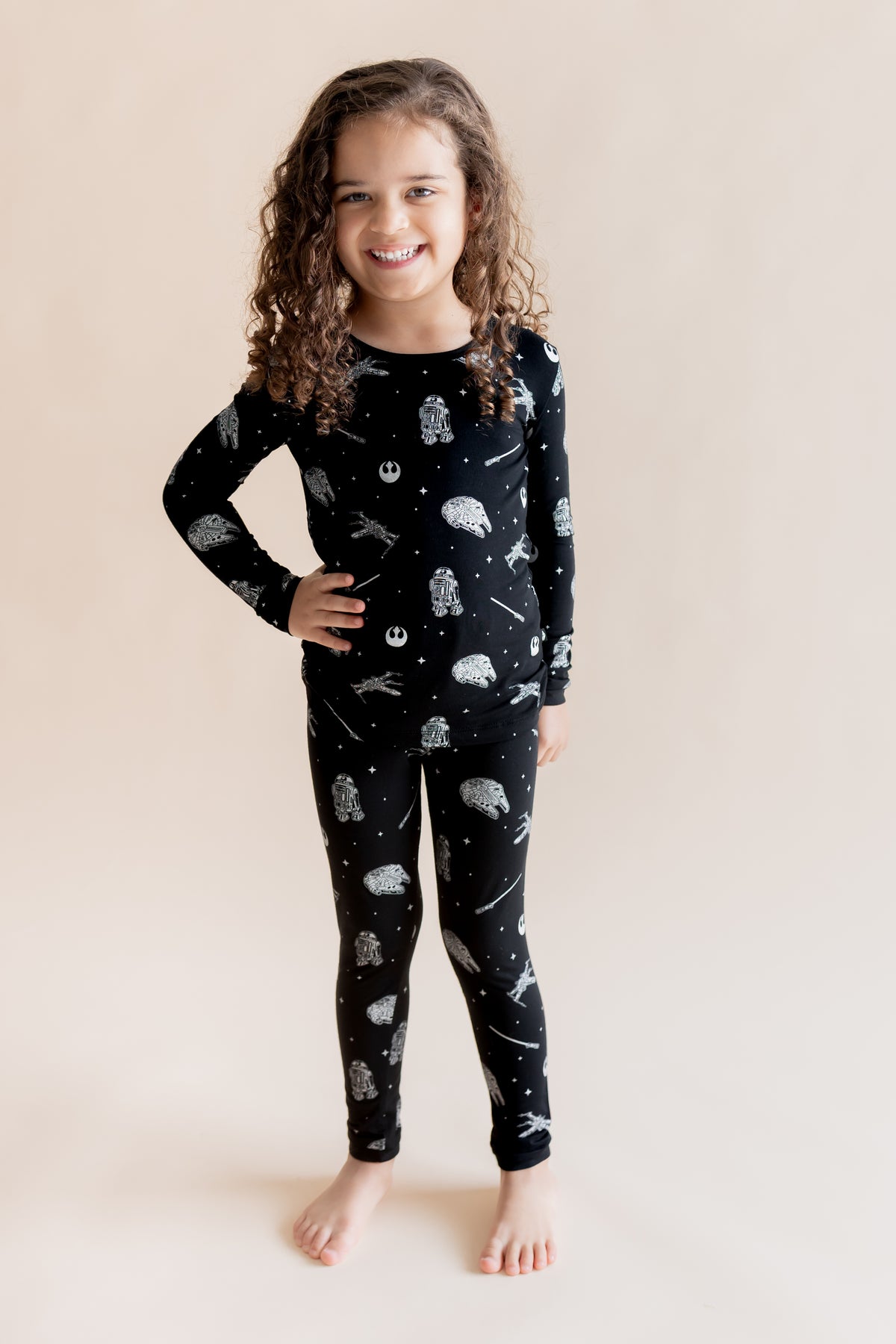 Girl wearing Long Sleeve Pajamas in STAR WARS™ print on a cream background