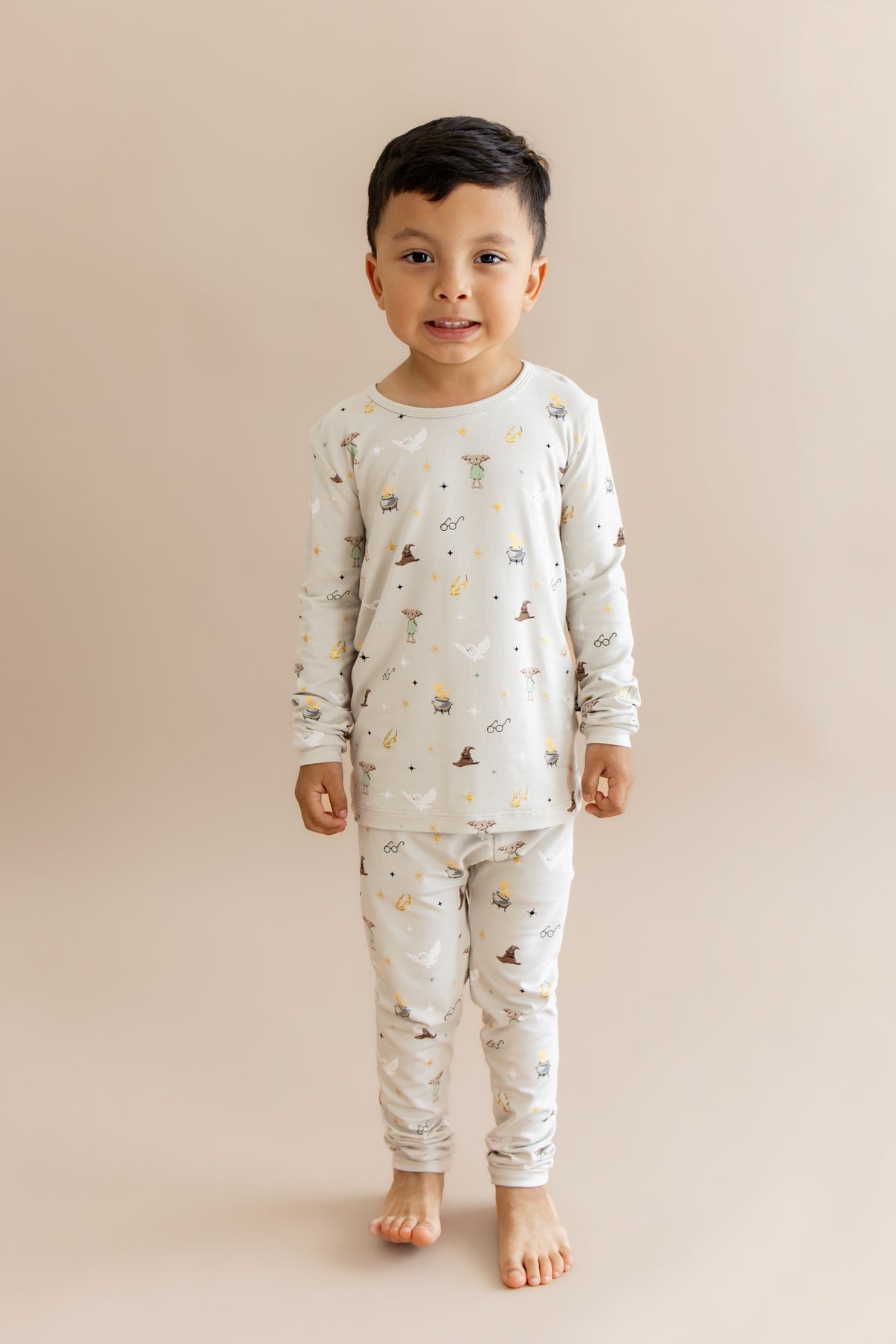 Child wearing a Harry Potter patterned pajama set on a beige background